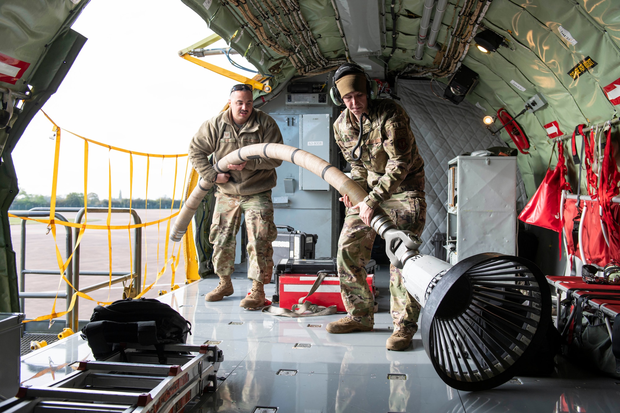U.S. Air Force Tech. Sgt. Alexander Top, left, 100th Aircraft Maintenance Squadron flight line expediter, and Senior Airman Jaroe Tuttle, right, 100th AMXS assistant flying crew chief, load equipment onto a 100th Air Refueling Wing’s KC-135 Stratotanker at Royal Air Force Fairford, England, Nov. 2, 2021. Airmen from the 100th Air Refueling Wing conducted operations out of RAFF as part of an Agile Combat Employment exercise. Utilizing ACE concepts ensures that U.S. forces in Europe are better equipped to operate from locations with varying levels of capacity and support to accomplish the mission. This further ensures Airmen and aircrews are postured to deliver lethal combat power across the full spectrum of military operations. (U.S. Air Force photo by Senior Airman Jennifer Zima)