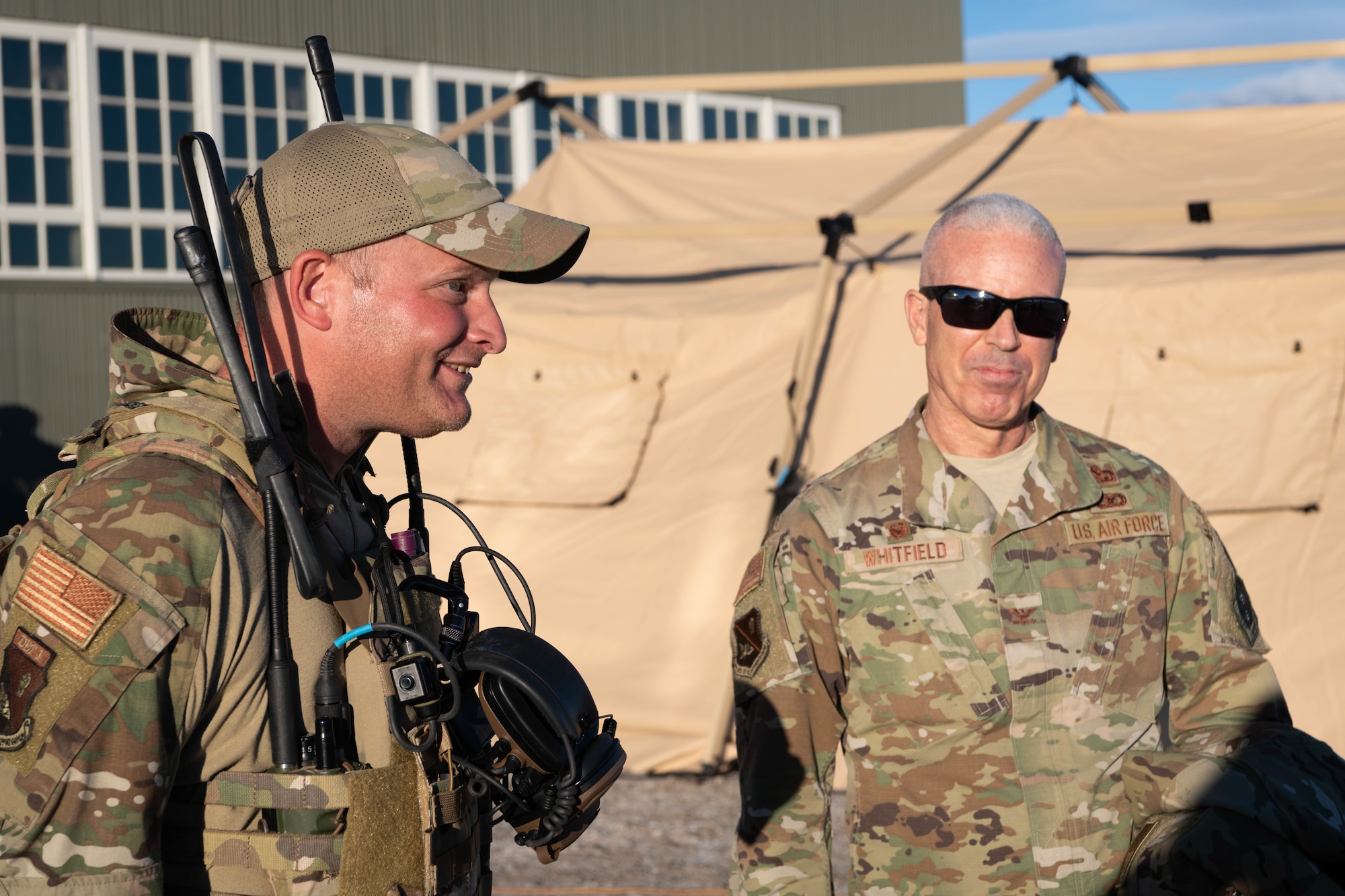 Senior Master Sergeant John Spencer briefs Colonel Bernabe Whitfield in front of a tent.