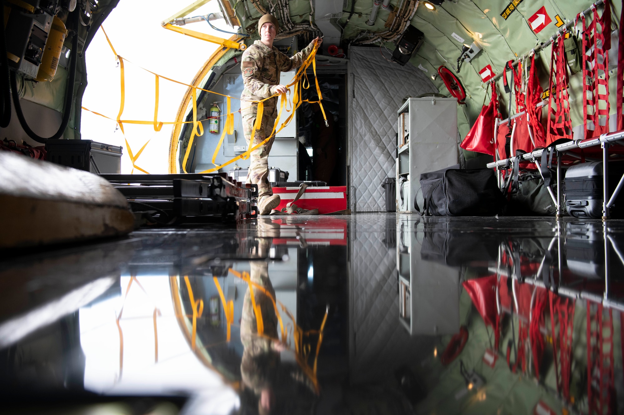 U.S. Air Force Senior Airman Jaroe Tuttle, 100th Aircraft Maintenance Squadron assistant flying crew chief, puts up a safety net in the cargo door of a KC-135 Stratotanker at Royal Air Force Fairford, England, Nov. 2, 2021. Airmen from the 100th Air Refueling Wing conducted operations out of RAFF as part of an Agile Combat Employment exercise. Utilizing ACE concepts ensures that U.S. forces in Europe are better equipped to operate from locations with varying levels of capacity and support to accomplish the mission. This further ensures Airmen and aircrews are postured to deliver lethal combat power across the full spectrum of military operations. (U.S. Air Force photo by Senior Airman Jennifer Zima)