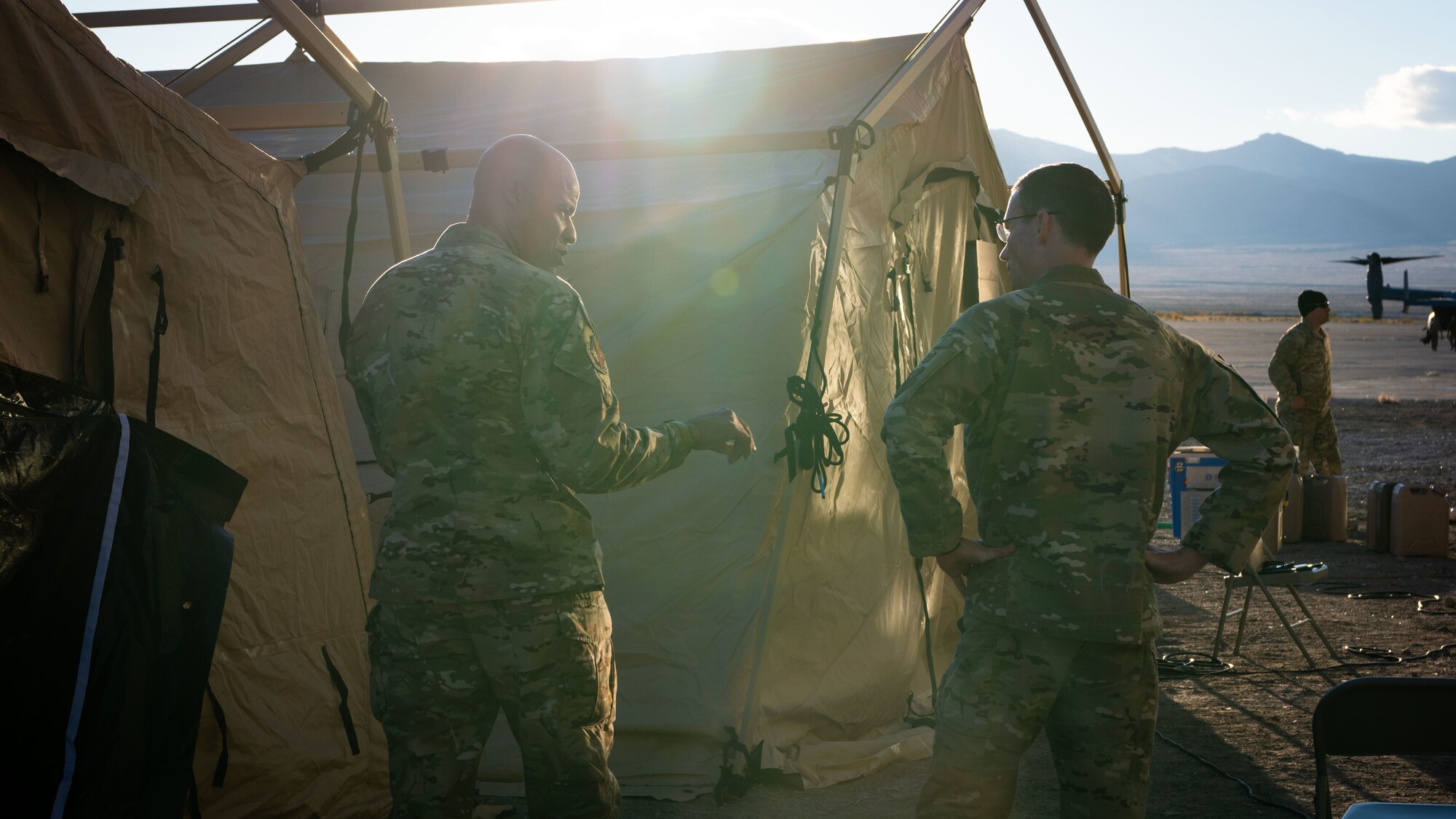 Colonel Terence Taylor receives a brief in front of a tent from Major Travis Burns.