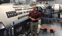 Lt. Col. Jon Vos, an Army space operations officer, stands in front of an International Space Station simulator at Johnson Space Center in Houston, Texas, in 2020. Vos is near the end of his tour at the Army Detachment at NASA, where he did everything from developing new hardware to return astronauts to the moon, to providing quality control on spacecraft hardware prior to integration and launch. (Photo courtesy of Lt. Col. John Vos/RELEASED)