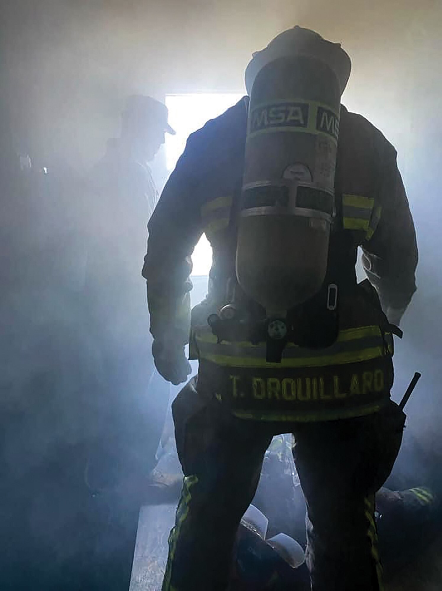 Staff Sgt. Thomas Drouillard, 445th Civil Engineer Squadron, navigates a smoke-filled building wearing full firefighter turnout gear during the DOD firefighter rescue and survival course at Grissom Air Reserve Base, Indiana, Sept. 20-24, 2021. The students practiced using ropes, carabiners, firehose, webbing, and more to rescue downed firefighters inside a burning building, mirroring the historic, real circumstances which tragically resulted in loss of life.