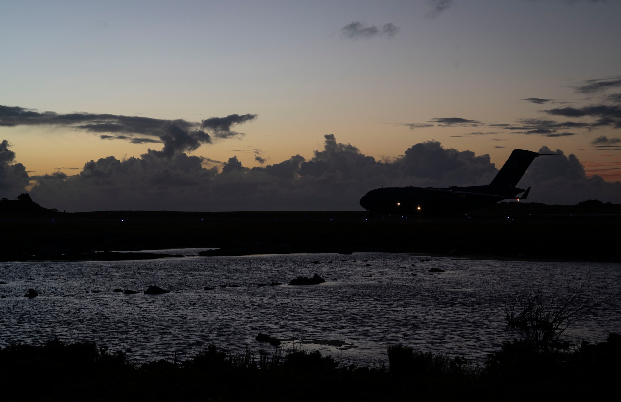 A C-17 Globemaster III assigned to Joint Base Lewis-McChord, Washington, lands at Wake Island during Exercise Rainier War 21B, Nov. 5, 2021. Rainier War 21B exercised and evaluated the 62nd Airlift Wing’s ability to employ the force and their ability to perform during wartime and contingency taskings in a high-intensity, wartime contested, degraded and operationally limited environment while supporting the contingency operations against a near-peer adversary in the U.S. Indo-Pacific Command area of responsibility. (U.S. Air Force photo by Staff Sgt. Rachel Williams)
