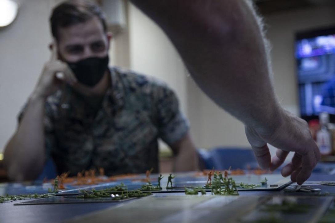 U.S. Marine Corps officers assigned to the 22nd Marine Expeditionary Unit conduct a wargaming scenario aboard Amphibious Assault Ship USS Kearsarge, Oct. 22, 2021. The wargame was an exercise used by the Marine officers to increase proficiency in real-time decision making during PHIBRON-MEU Integrated Training. PMINT is the first at-sea period in the MEU’s Pre-deployment Training Program; it aims to increase interoperability and build relationships between Marines and Sailors.