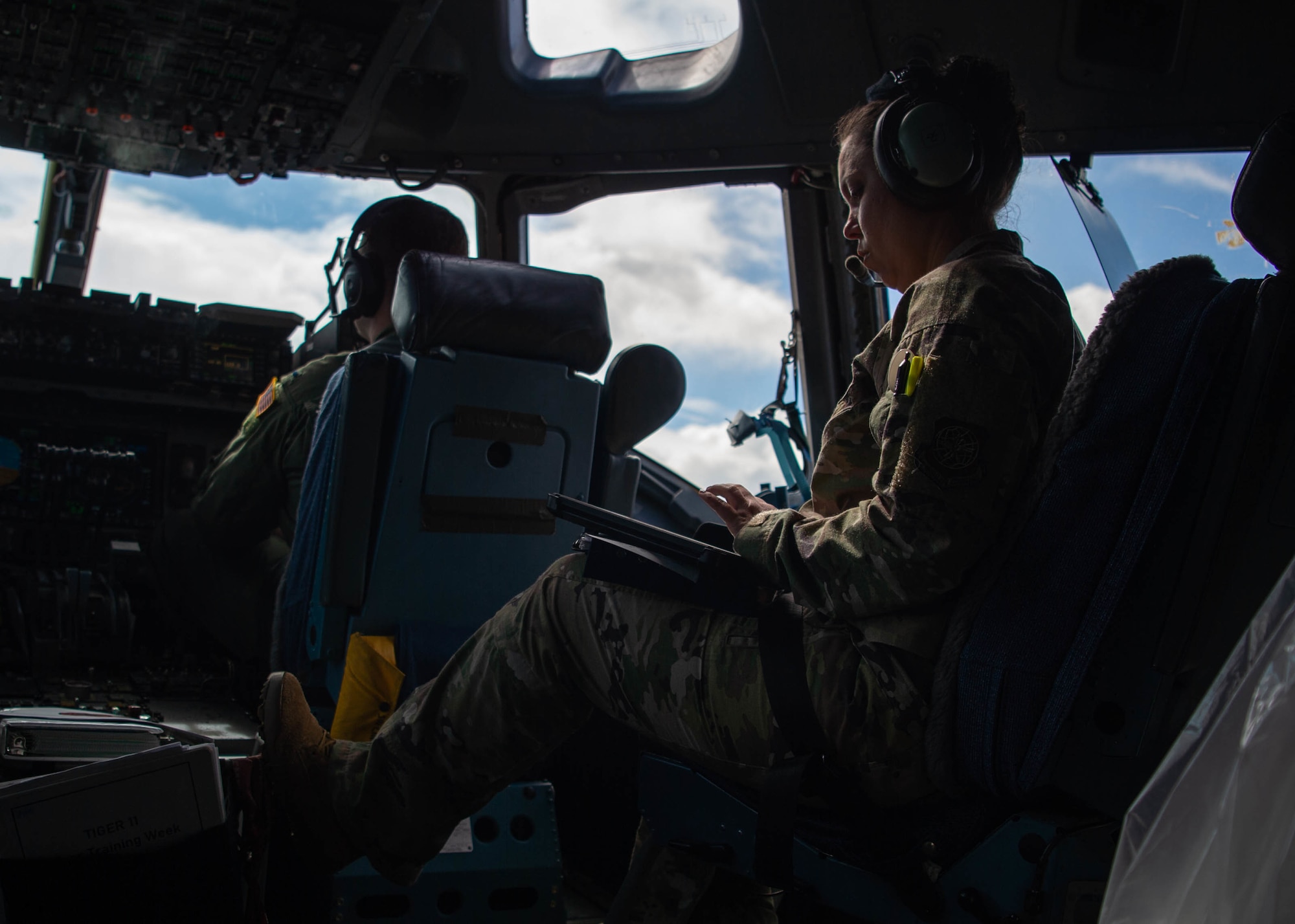 Lt. Col. Jamila Fitzpatrick, 6th Airlift Squadron flight commander, calls out injects from a playbook during the 535th Airlift Squadron’s quarterly training around the Hawaiian Islands, Nov. 3, 2021. Air Mobility Command and Pacific Air Forces Airmen flew over the Hawaiian islands engaging in several in-flight training scenarios. (U.S. Air Force photo by Senior Airman Alan Ricker)