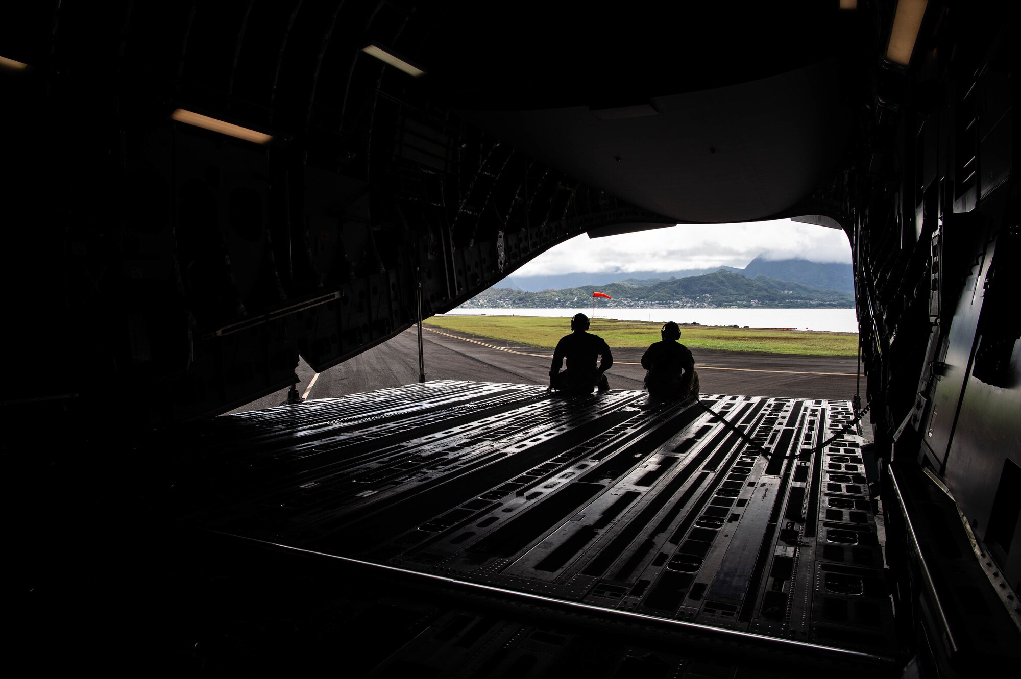 Tech. Sgt. Todd Hanggeli, 6th Airlift Squadron instructor loadmaster, and Airman 1st Class Thomas Dodd, 6th AS loadmaster, call out instructions over the intercom during a 90-degree backing training on a C-17 Globemaster III at Marine Corps Base Hawaii, Hawaii, Nov. 3, 2021. Four Airmen assigned to Joint Base McGuire-Dix Lakehurst, New Jersey, supported the 535th Airlift Squadron during a quarterly training week. (U.S. Air Force photo by Senior Airman Alan Ricker)