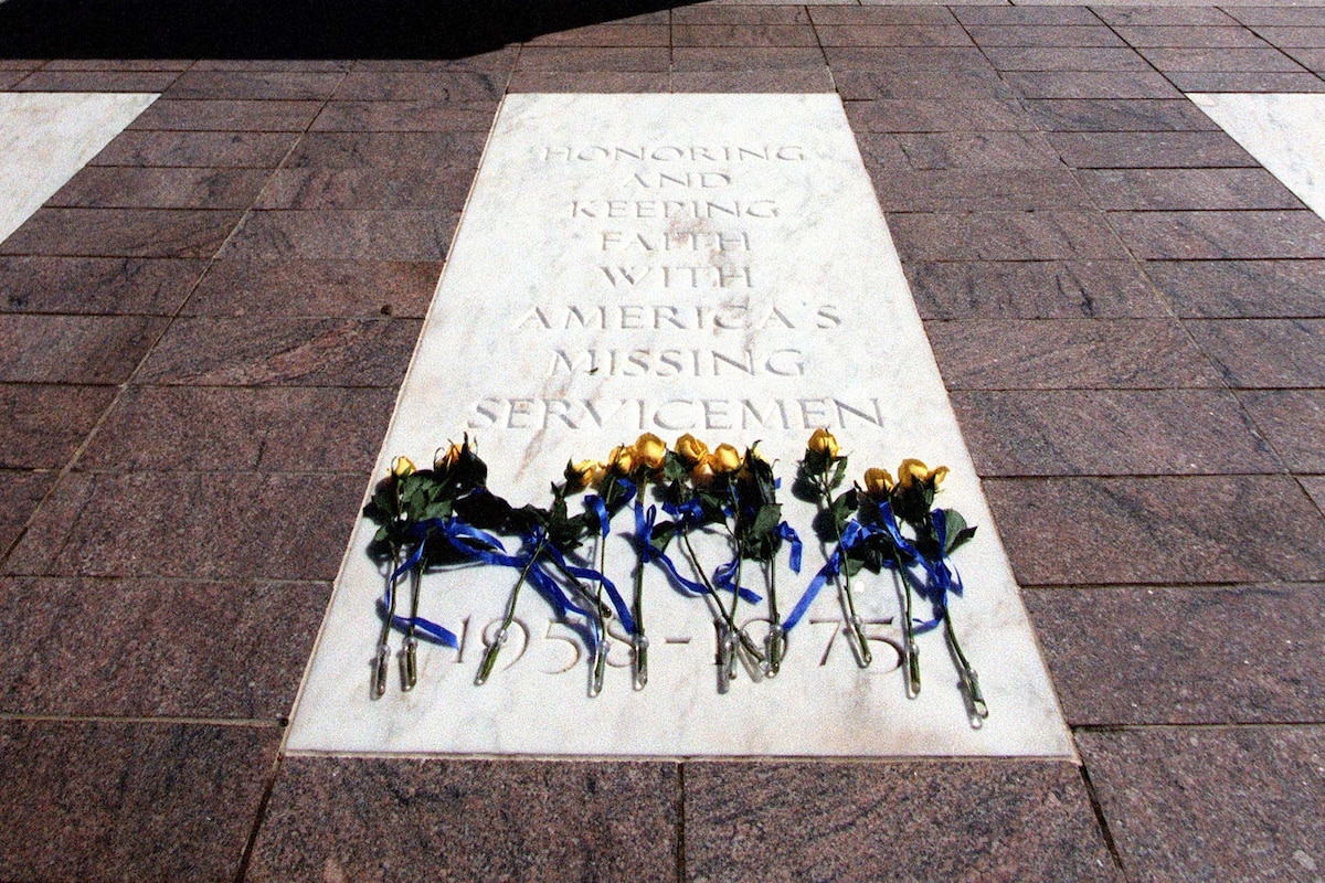 Flowers sit on a white crypt.