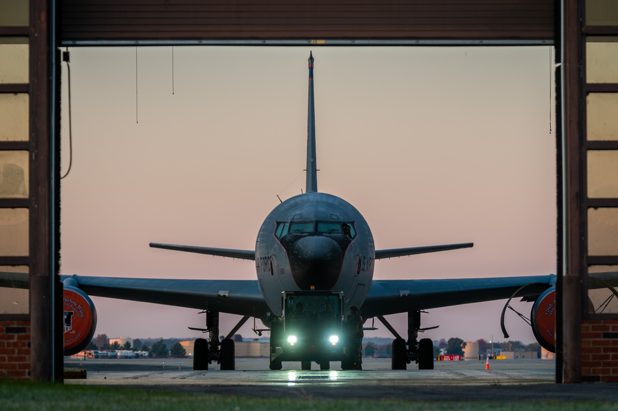KC-135 tanker plane being pulled into a hanger.
