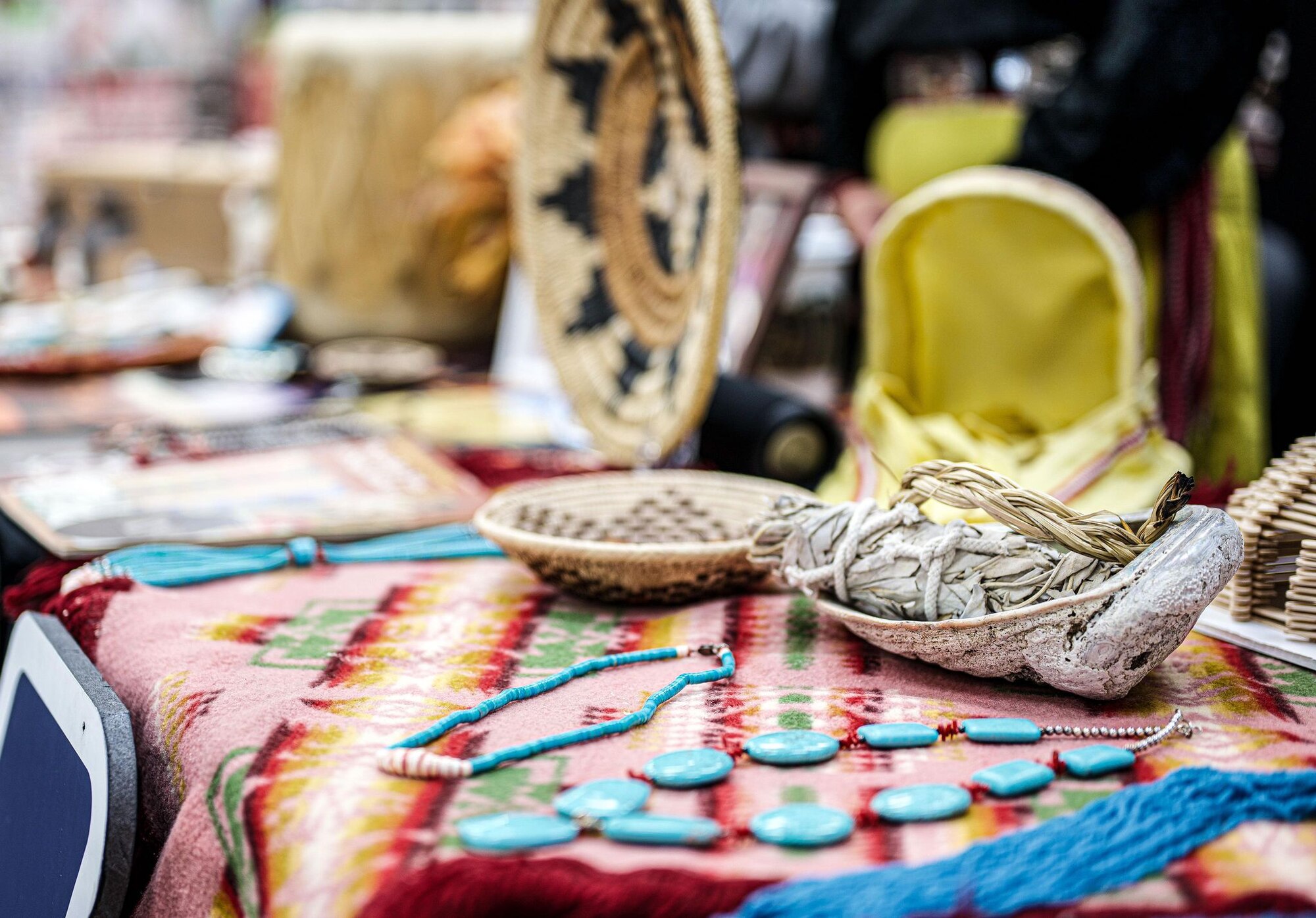 Native American items are displayed on a table under fluorescent lighting