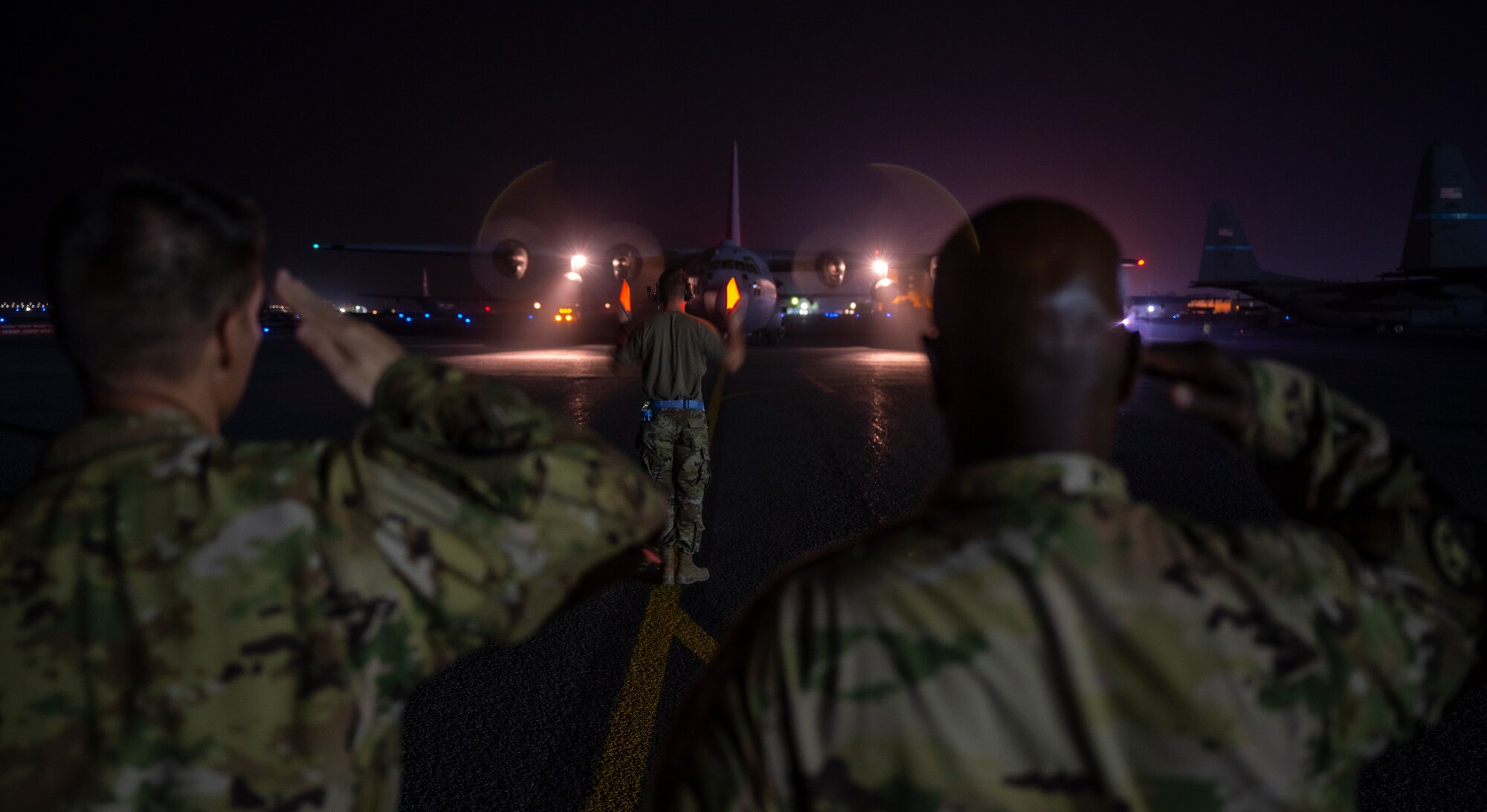 Members from the 779th Expeditionary Airlift Squadron wait for personnel to depart a C-130H Hercules at Ali Al Salem Air Base, Kuwait, Nov. 2, 2021.