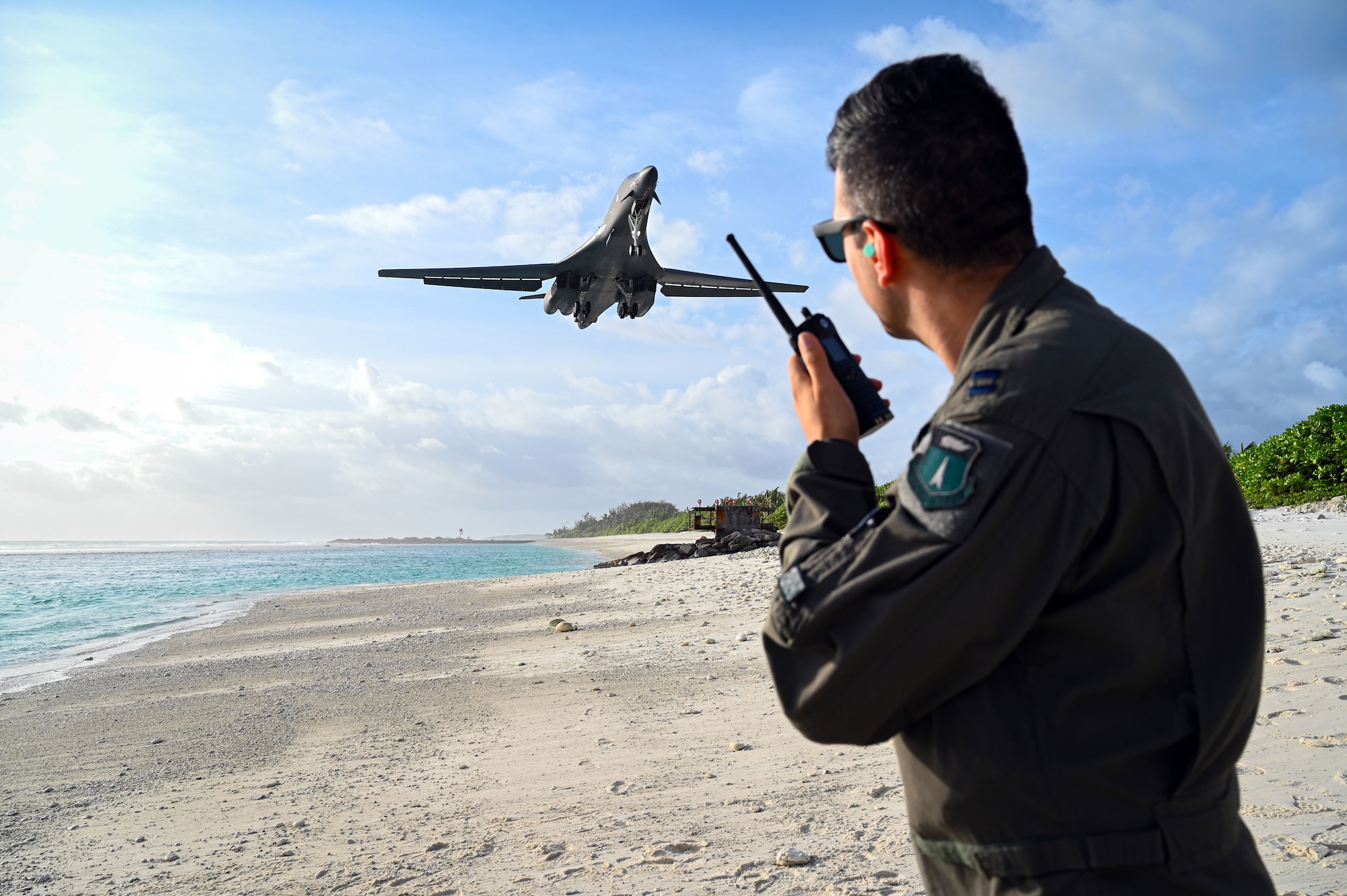 A weapons systems officer uses a land mobile radio as he watches a B-1B Lancer land