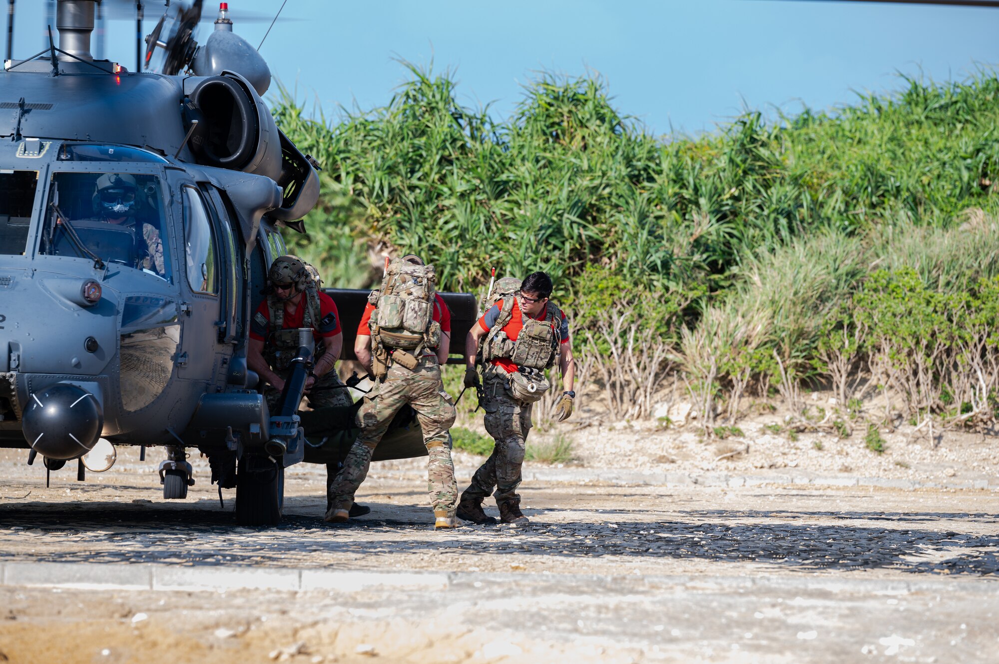 Pararescue jumpers offload from a helicopter.