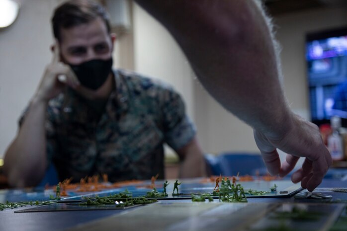 U.S. Marine Corps officers assigned to the 22nd Marine Expeditionary Unit (MEU) conduct a wargaming scenario aboard Amphibious Assault Ship USS Kearsarge (LHD 3), Oct. 22, 2021. The wargame was an exercise used by the Marine officers to increase proficiency in real-time decision making during PHIBRON-MEU Integrated Training (PMINT). PMINT is the first at-sea period in the MEU’s Pre-deployment Training Program; it aims to increase interoperability and build relationships between Marines and Sailors.