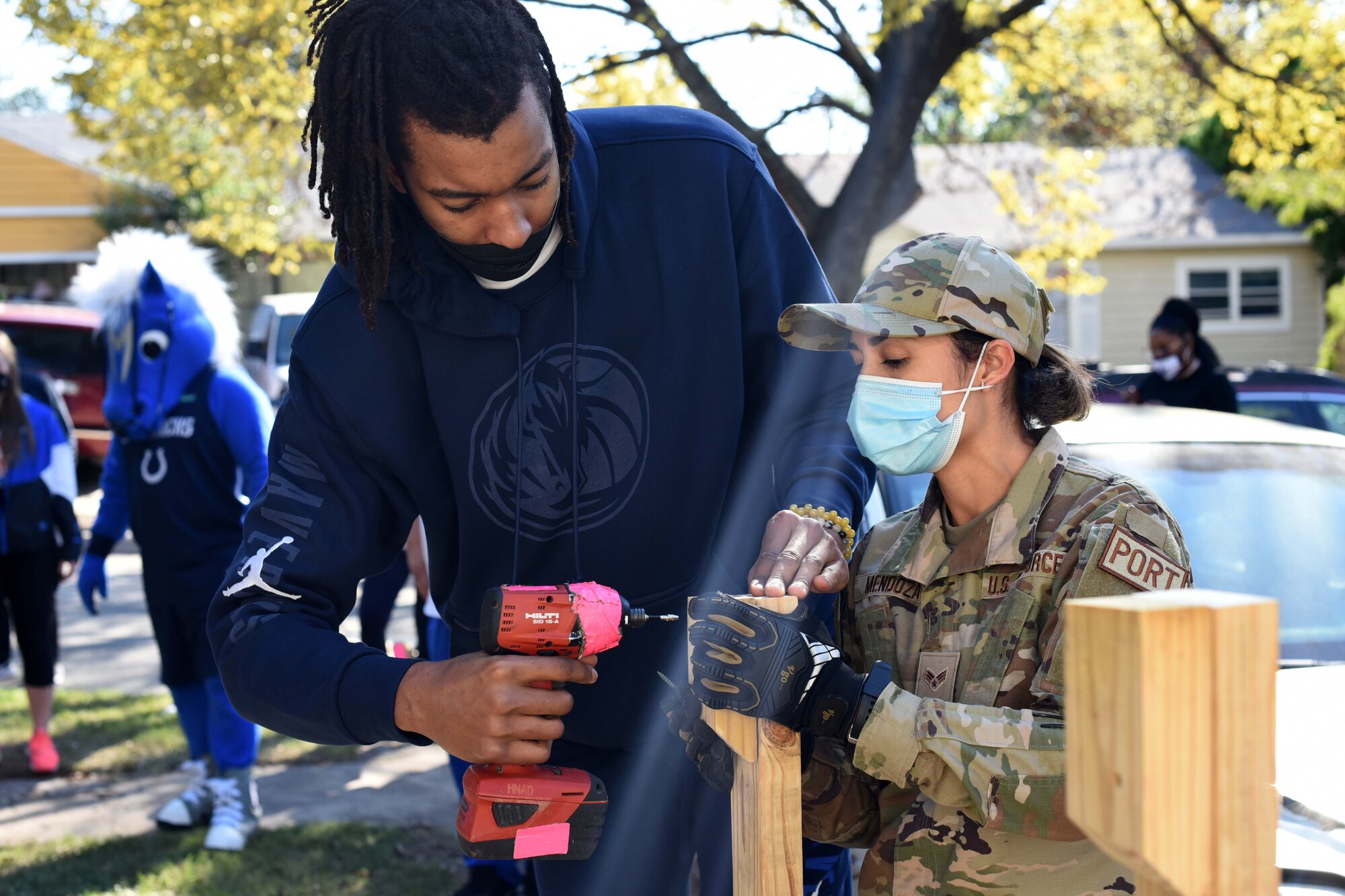 Moses Brown, Dallas Mavericks center number 9, and Senior Airman Laura Mendoza, 73rd Aerial Port Squadron porter, assemble a ramp during a Hoops for Troops event in Dallas, Texas on November 6, 2020.  The event allows military members to volunteer with NBA employees, coaches and players to make positive impacts in their local areas. (U.S. Air Force photo by Staff Sgt. Randall Moose)