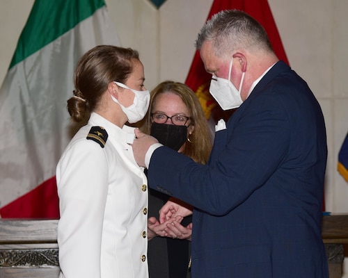 Lt j.g. Suzelle Thomas’ parents pin on her naval aviator Wings of Gold during a ceremony.