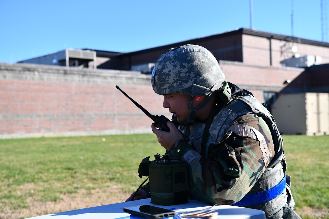 Airman First Class Joshua Towse, emergency management specialist with the 104th Civil Engineer Squadron, relays a message into a hand-held radio during a midpoint inspection on November 5, 2021 at Barnes Air National Guard Base, Massachusetts. Midpoint inspections are conducted to evaluate the wing’s capabilities to respond to threats in a contested, degraded, and operationally limited environment. (U.S. Air National Guard photo by Senior Airman Camille Lienau)