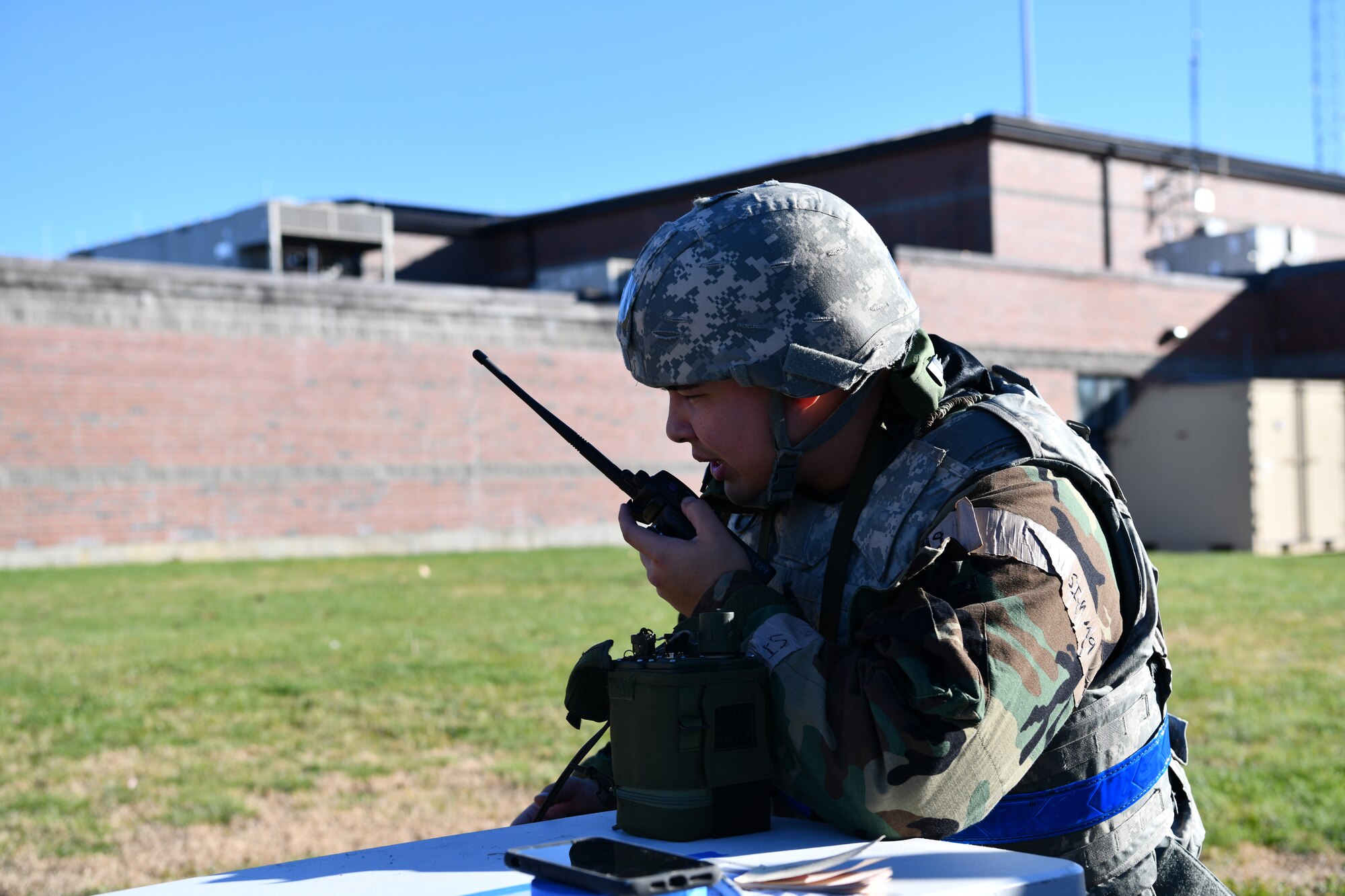 Airman First Class Joshua Towse, emergency management specialist with the 104th Civil Engineer Squadron, relays a message into a hand-held radio during a midpoint inspection on November 5, 2021 at Barnes Air National Guard Base, Massachusetts. Midpoint inspections are conducted to evaluate the wing’s capabilities to respond to threats in a contested, degraded, and operationally limited environment. (U.S. Air National Guard photo by Senior Airman Camille Lienau)