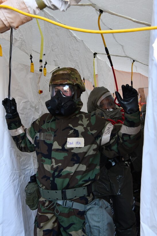 Staff Sgt. London Brown, a medical admin specialist with the 104th Medical Group, simulates decontaminating and providing medical aid to Airman 1st Class Alexander Laine, Aviation Reconfigurable Manned Simulator specialist with the 104th Operations Support Flight, during a midpoint inspection readiness exercise November 6, 2021, at Barnes Air National Guard Base, Massachusetts. Midpoint inspections are conducted to evaluate the wing’s capabilities to respond to threats in a contested, degraded, and operationally limited environment. (U.S. Air National Guard photo by Staff Sgt. Hanna Smith)