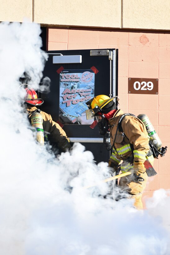 Firefighters with the 104th Civil Engineer Squadron enter into a simulated building fire during a midpoint inspection readiness exercise November 6, 2021 at Barnes Air National Guard Base, Massachusetts. Midpoint inspections are conducted to evaluate the wing’s capabilities to respond to threats in a contested, degraded, and operationally limited environment. (U.S. Air National Guard photo by Staff Sgt. Hanna Smith)