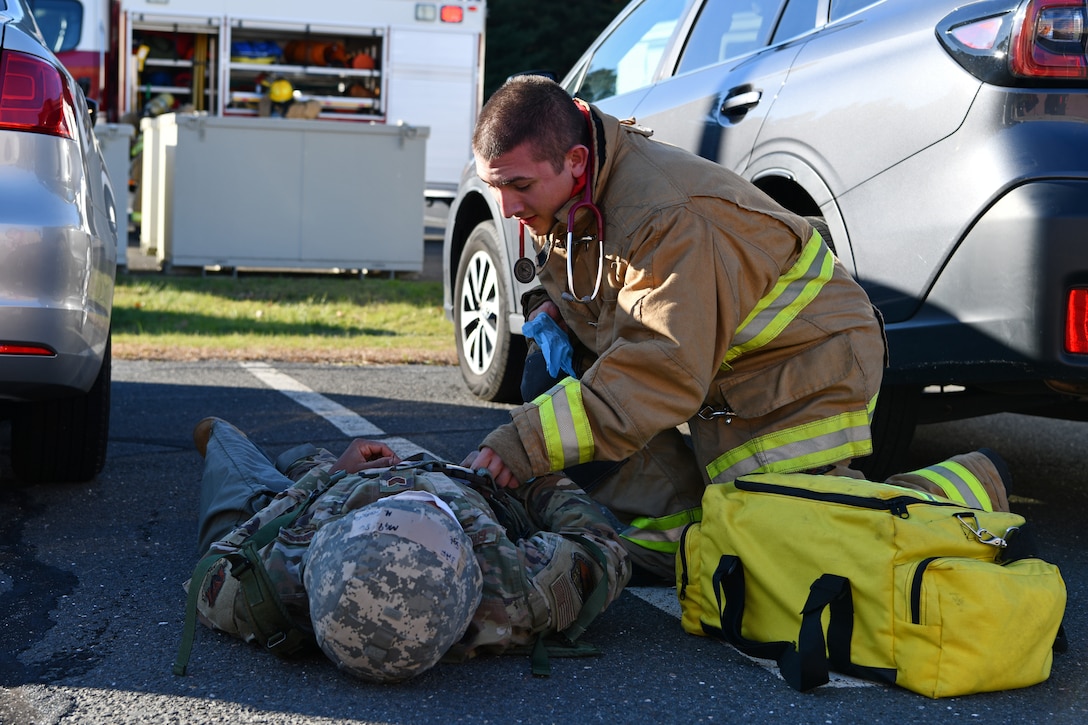 Airman 1st Class Jacob Parent, firefighter with the 104th Civil Engineer Squadron, attends to simulated casualty Staff Sgt. Marie Georgefils, communications specialist with the 104th Communications Flight, during a midpoint inspection readiness exercise November 6, 2021 at Barnes Air National Guard Base, Massachusetts. Midpoint inspections are conducted to evaluate the wing’s capabilities to respond to threats in a contested, degraded, and operationally limited environment. (U.S. Air National Guard photo by Staff Sgt. Hanna Smith)