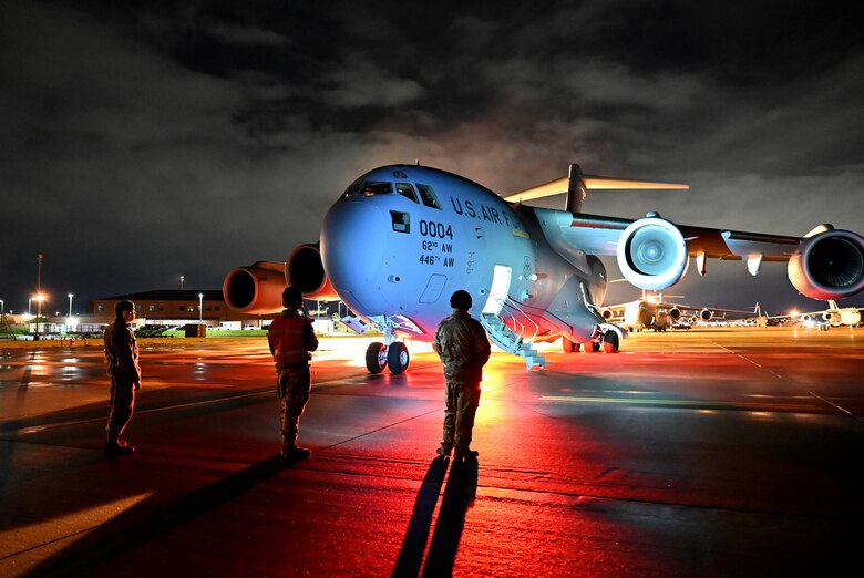 U.S. Air Force Airmen with 62nd Airlift Wing prepare a C-17 Globemaster III prior to a night-time airlift mission as part of Exercise Rainier War 21B at Joint Base Lewis-McChord, Washington, Nov. 6, 2021. Rainier War is a semi-annual, large readiness exercise led by 62nd Airlift Wing, designed to train aircrews under realistic scenarios that support a full spectrum readiness operations against modern threats and replicate today’s contingency operations. (U.S. Air Force photo by Master Sgt. Julius Delos Reyes)