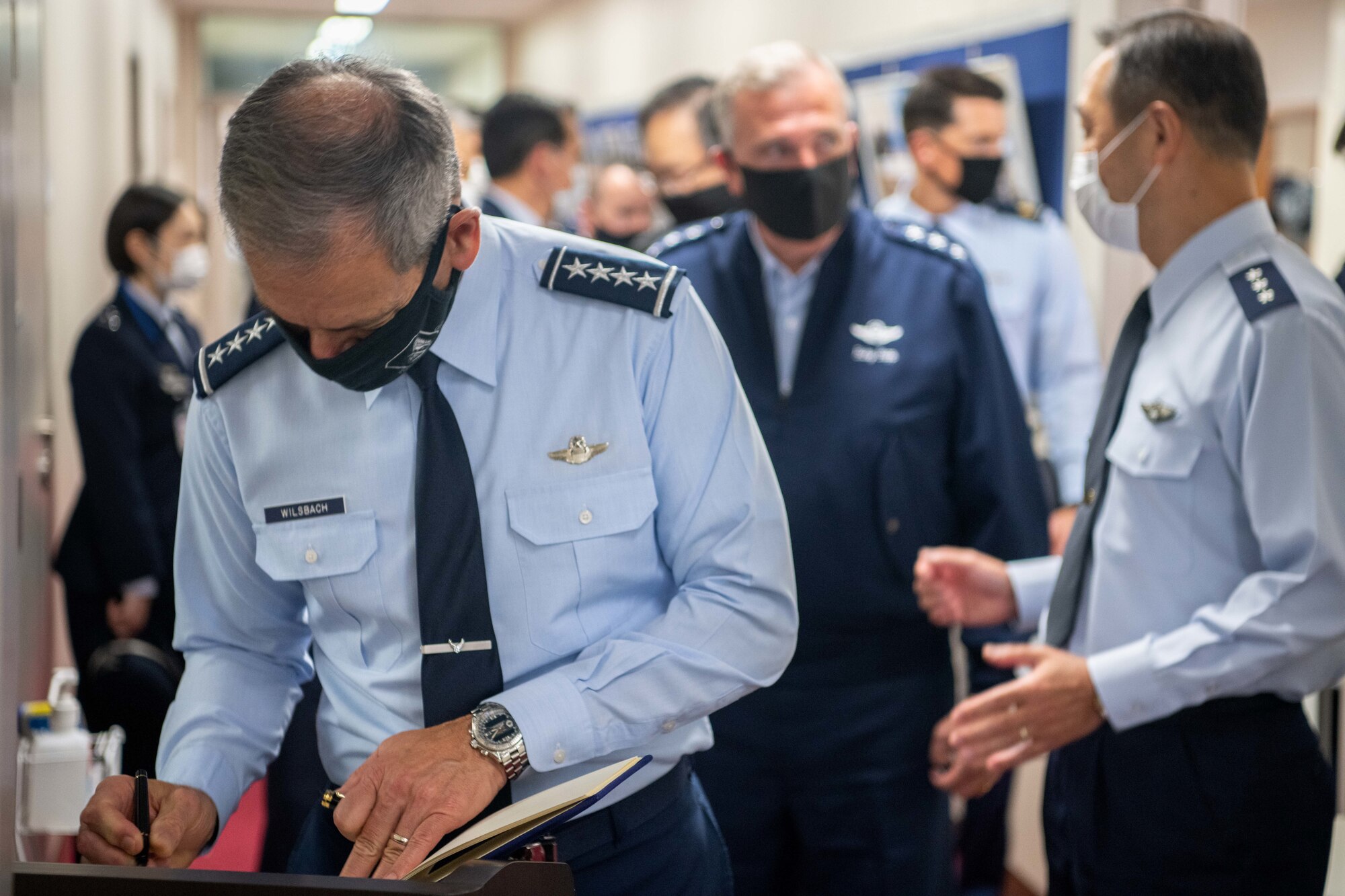 U.S. Air Force Gen. Ken Wilsbach, Pacific Air Forces (PACAF) commander, signs a guestbook during an annual site tour of U.S. Air Force and allied commands at Yokota Air Base