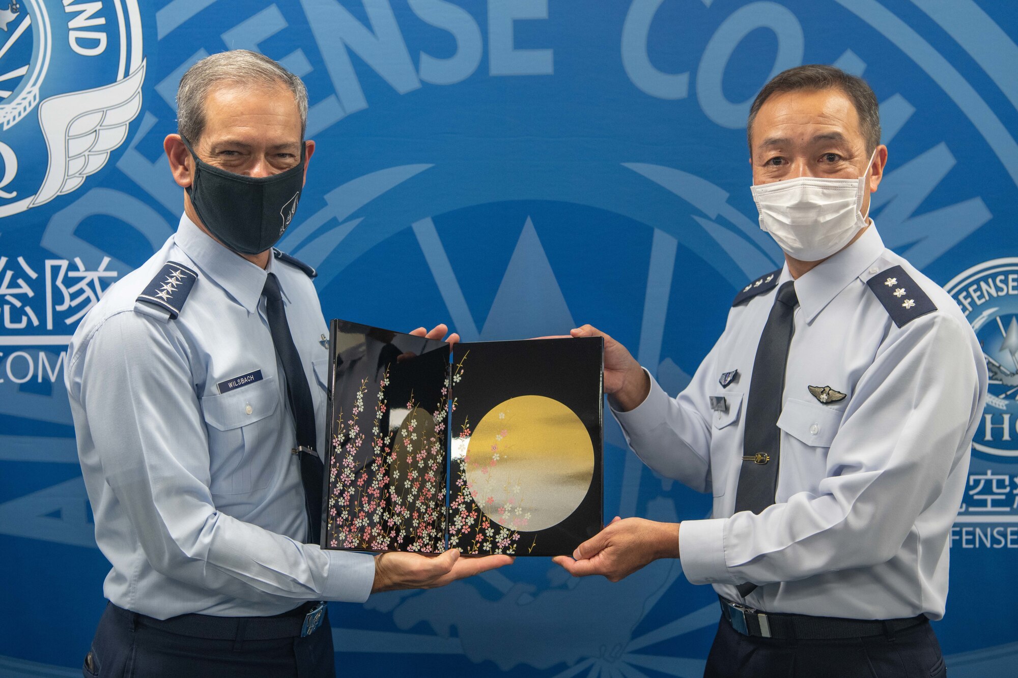 U.S. Air Force Gen. Ken Wilsbach, Pacific Air Forces commander, left, and Lt. Gen. Hiroaki Uchikura, Japanese Air Self-Defense Force, Air Defense Command commander, exchange gifts during an annual site tour of U.S. Air Force and allied commands at Yokota Air Base