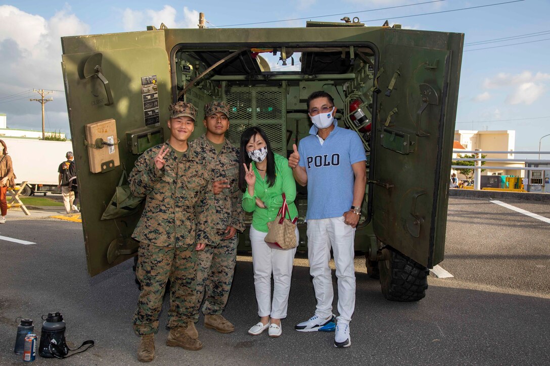 CAMP SCHWAB, OKINAWA, Japan – Okinawa residents and U.S. Marines pose for a photo next to a Light Armored Vehicle static display during an open-gate festival at Camp Schwab, Okinawa, Japan, Nov. 7, 2021. The festival was the first open-gate event hosted on Marine Corps installations in Okinawa in over a year due to COVID-19. (U.S. Marine Corps Photo by Matthew Manning)