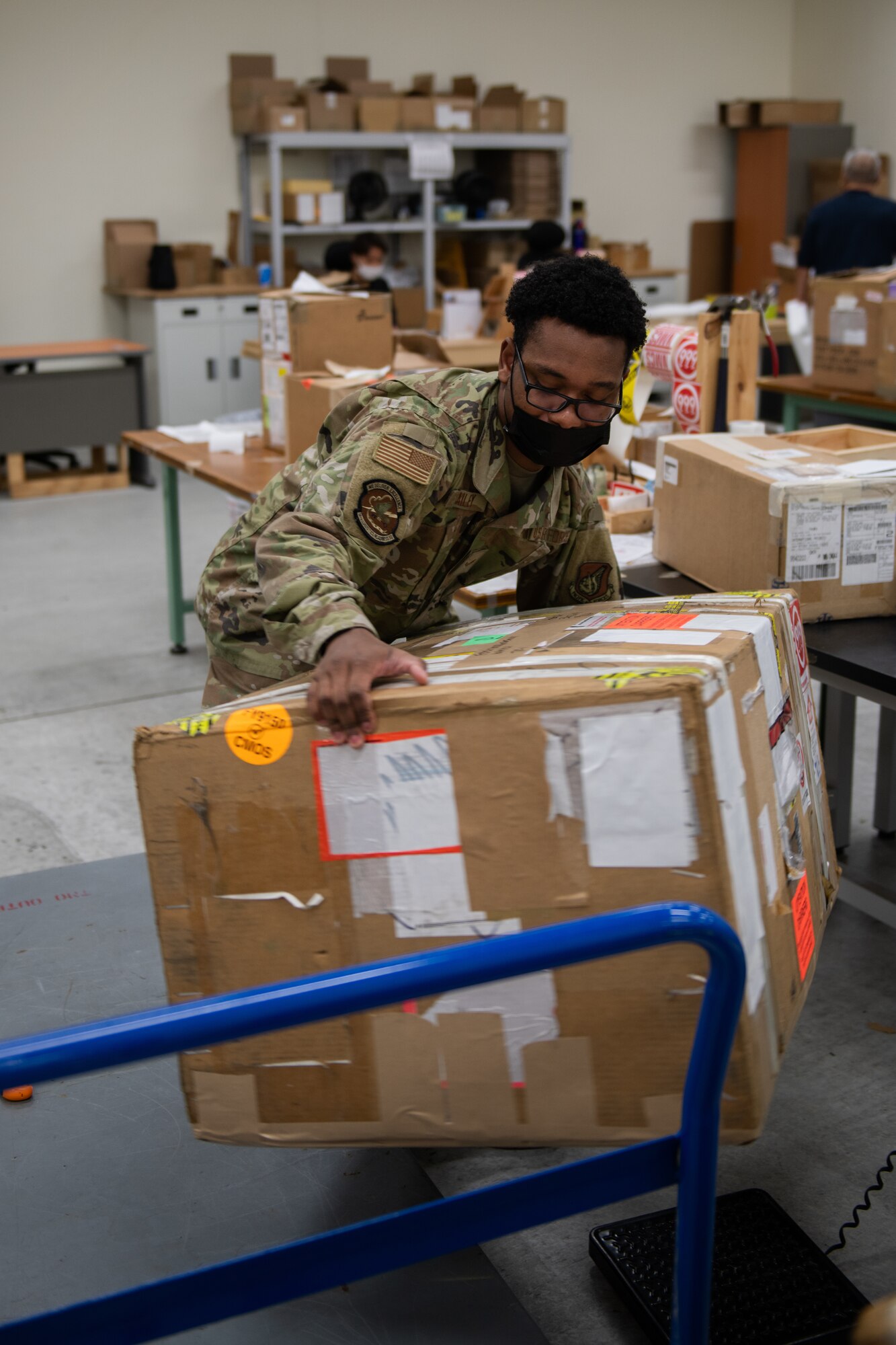 An Airman lifts a huge package onto a cart