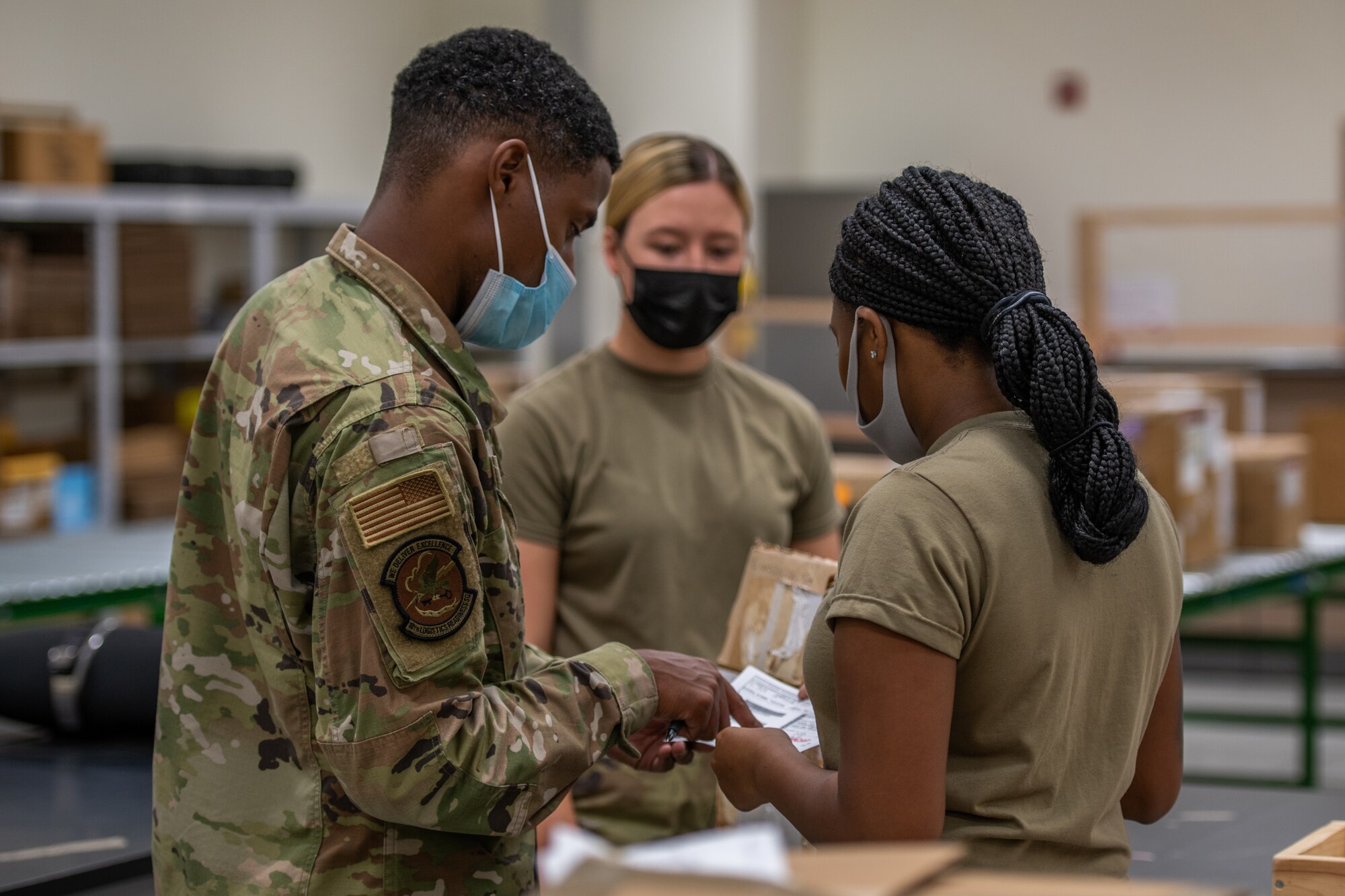 3 Airman discuss the categorization of a package