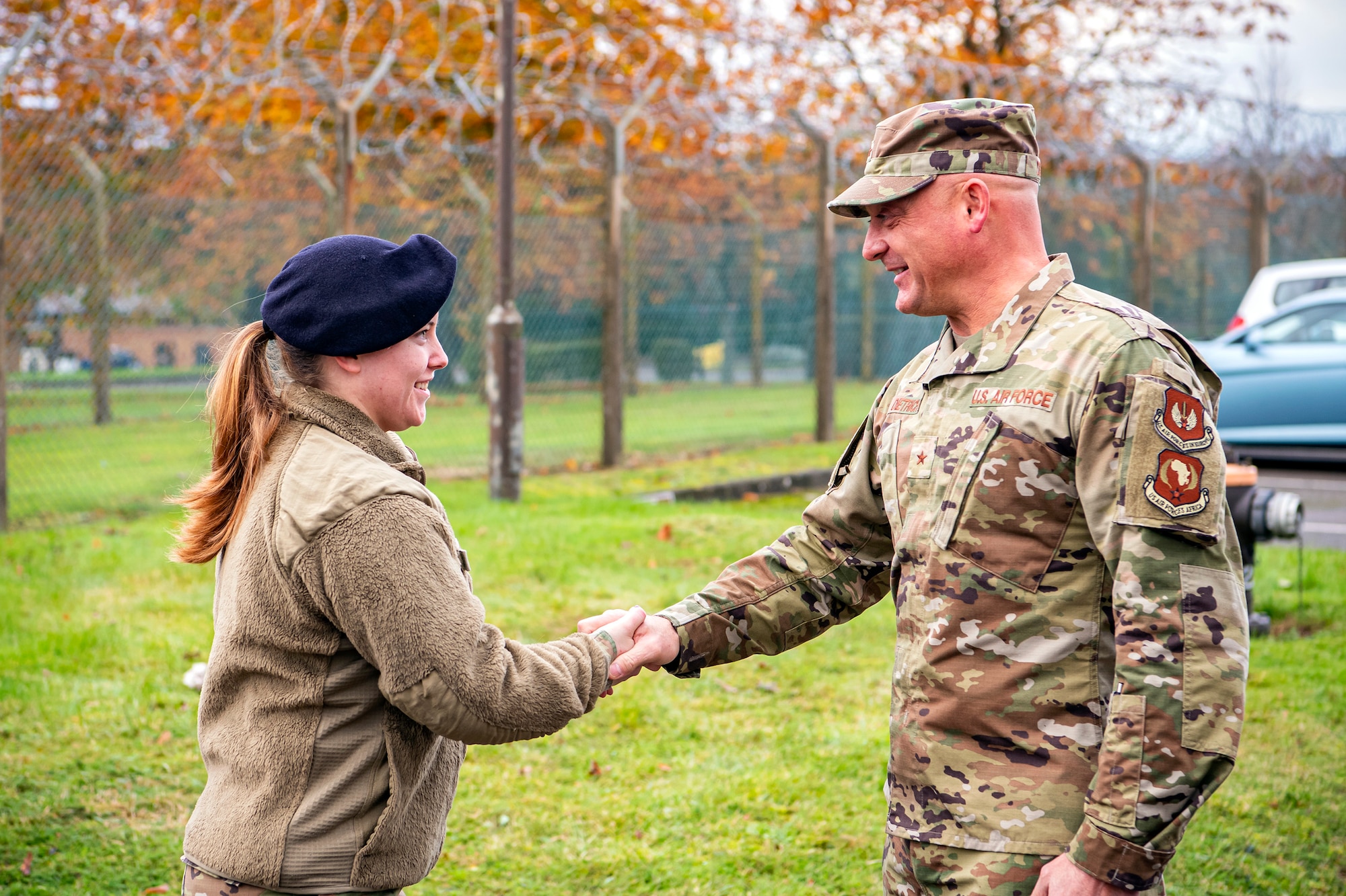 U.S. Air Force Brig. Gen. George T. Dietrich III, right, U.S. Air Forces in Europe - Air Forces Africa director of logistics, engineering and force protection, coins Airman 1st Class Zerina Zimbra-Morrison, 422d Security Forces Squadron restricted area entry controller, at RAF Croughton, England, Nov. 3, 2021. Dietrich visited with Airmen from five geographically separated units across the wing and learned more about the unique mission of the 501st CSW. (U.S. Air Force photo by Senior Airman Eugene Oliver)