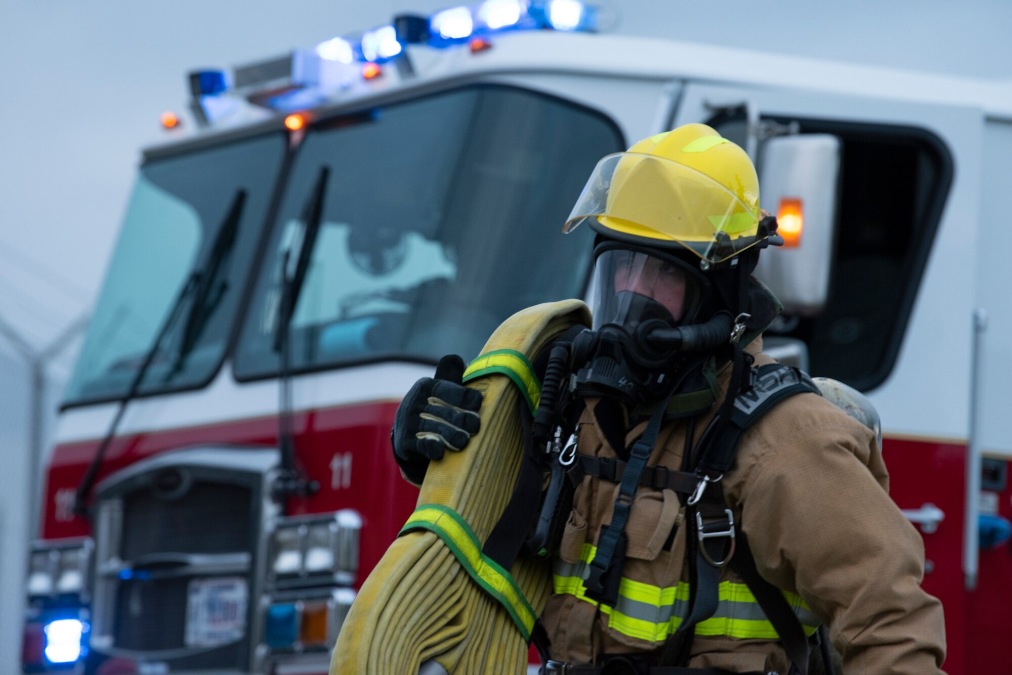 U.S. Air Force Airman from the 52nd Civil Engineer Squadron Fire and Emergency Services flight transports a fire hose, Nov. 4, 2021, on Spangdahlem Air Base, Germany. The 52nd FES and 52nd Medical Group participated in a simulated mass casualty response during exercise Sabre Storm, where they had to respond, evaluate and treat mock patients. (U.S. Air Force photo by Tech. Sgt. Anthony Plyler)