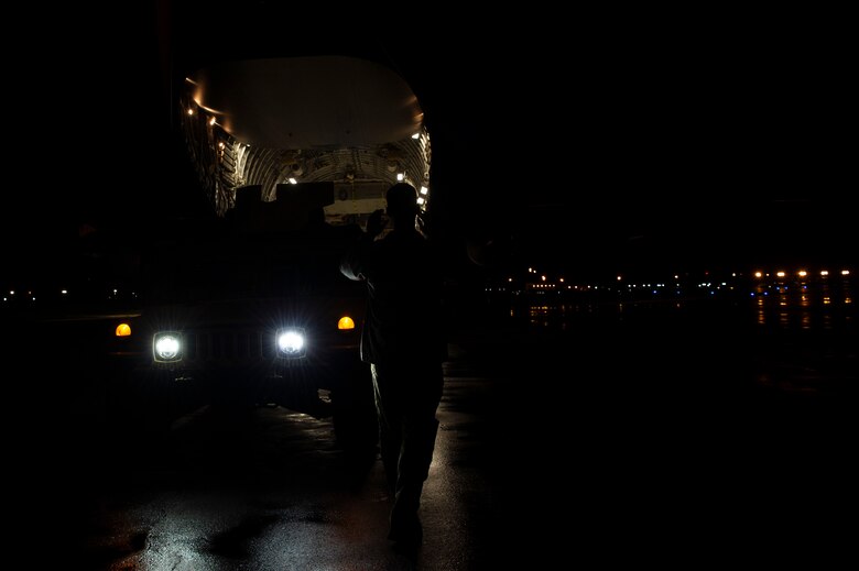 U.S. Air Force Senior Airman Keoni Gibson, 8th Airlift Squadron loadmaster, marshals a U.S. Army HUMVEE onto a C-17 Globemaster III during Exercise Rainier War 21B at Joint Base Lewis-McChord, Washington, Nov. 6, 2021. The exercise is designed to demonstrate the wing’s ability to operate and survive while defeating challenges to the U.S. military advantage in all operating domains – air, land, sea and cyberspace. (U.S. Air Force photo by Staff Sgt. Tryphena Mayhugh)