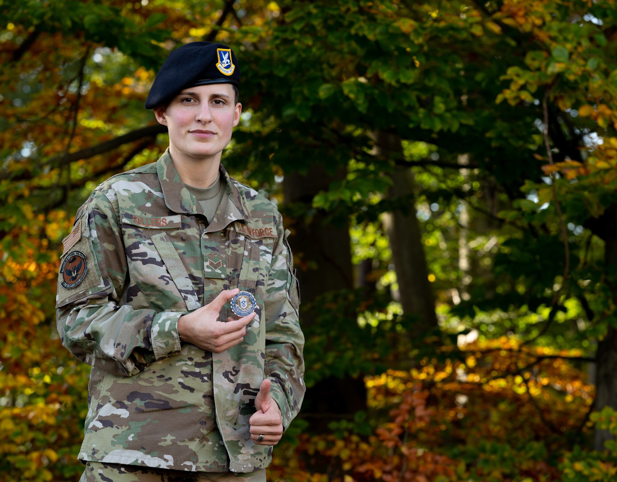 Airman holds coin happily.
