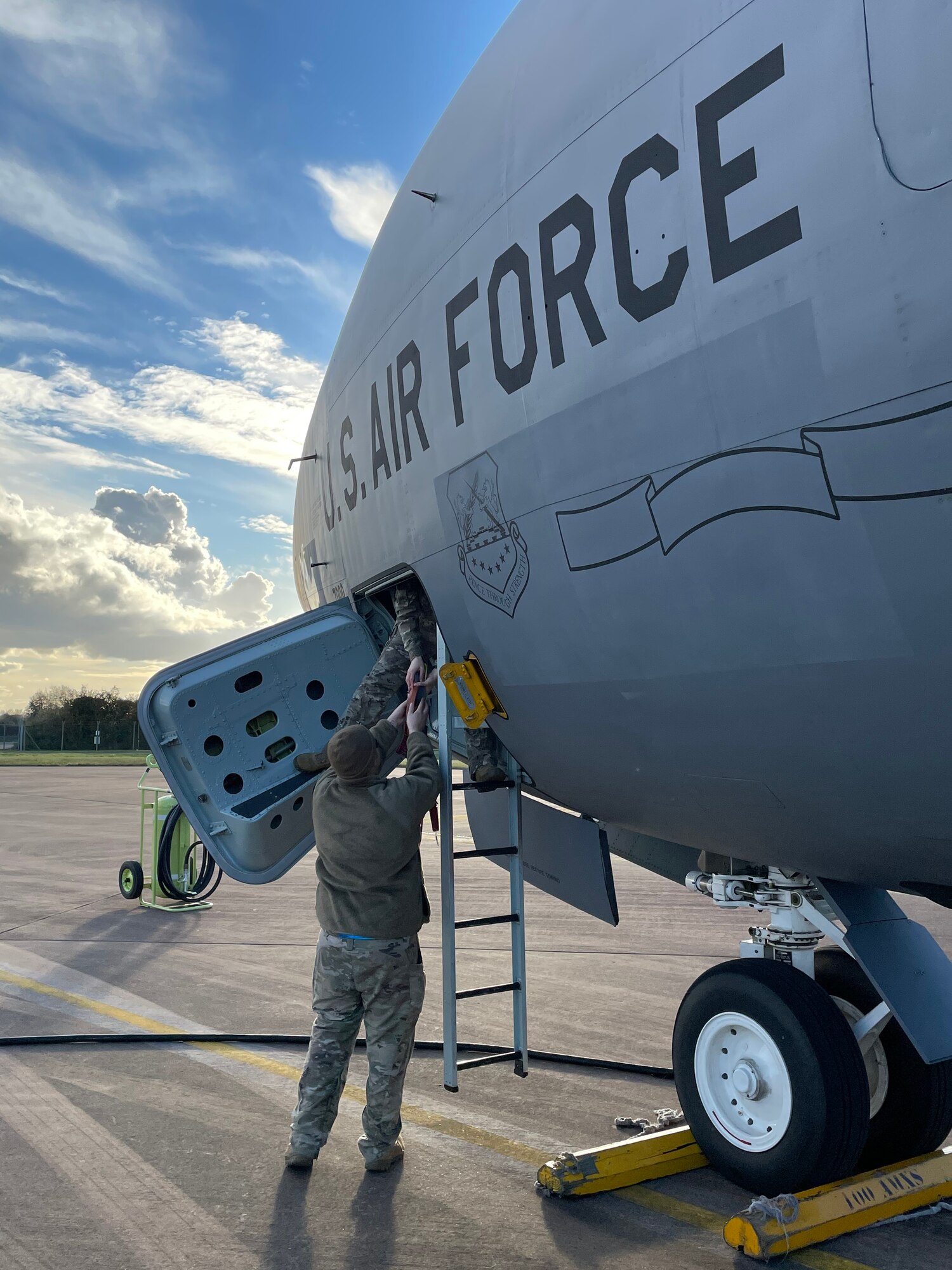 U.S. Air Force Staff Sgt. Benjamin Kellum, 100th Aircraft Maintenance Squadron flying crew chief, passes main landing gear locks through the crew entry door before an air refueling mission during exercise Castle Forge at Royal Air Force Fairford, England, Nov. 2, 2021. The ability to quickly respond and reassure allies and partners rests upon the U.S. Air Force’s forward and ready presence in Europe. In addition to F-15 Eagle aircraft operations in the Black Sea Region, Castle Forge encompasses the USAFE-wide Agile Combat Employment capstone event. Castle Forge’s components will better enable forces to quickly disperse and continue to deliver air power from locations with varying levels of capacity and support, ensuring Airmen are always ready to respond to potential threats.  (U.S. Air Force photo by Senior Airman Joseph Barron)