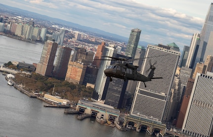 A New York Army National Guard UH-60 helicopter flies past lower Manhattan while carrying officers and noncommissioned officers taking part in the New York Army National Guard's Dense Urban Leaders Operations Course, to give participants a feel for the city's layout. The five-day course is geared to train and educate staff officers and senior noncommissioned officers in the planning and execution of operations in complex urban environments.