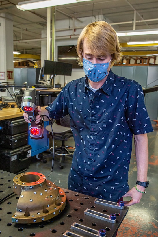 Hoellerich uses a 3-D measurement scanner to scan a part.