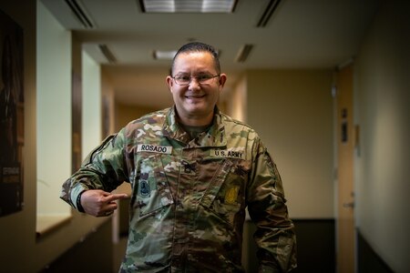 Male soldier pointing to a badge on his uniform.