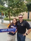 A man and a woman holding up a large arrow sign.