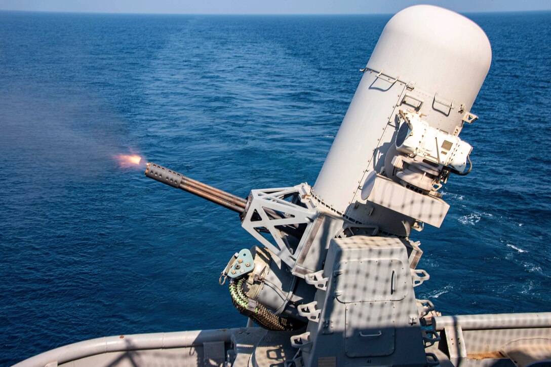A weapons system fires from a ship at sea.