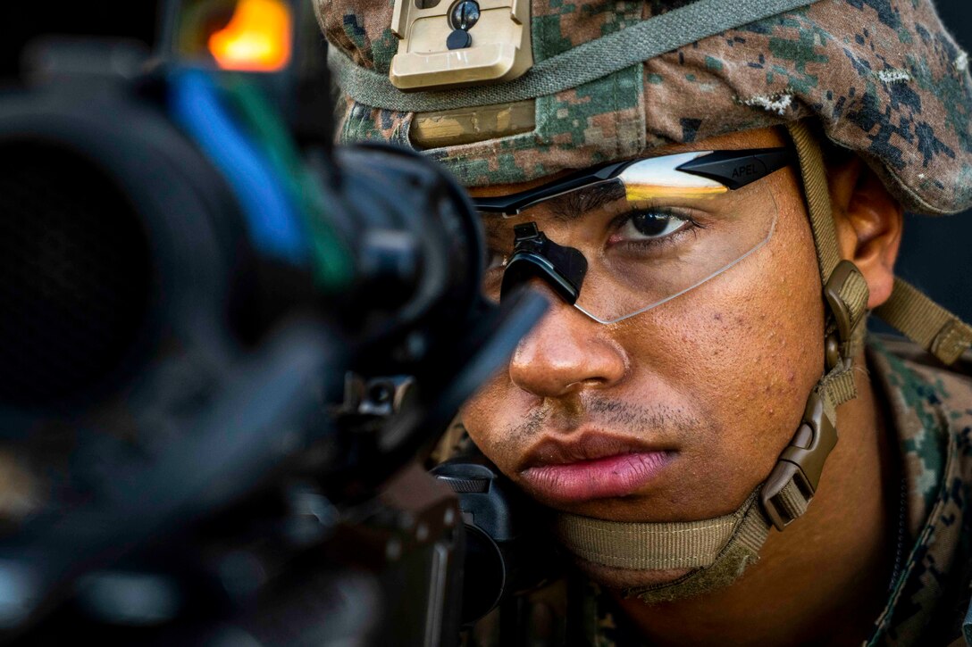 A Marine looks through the scope of a weapon.