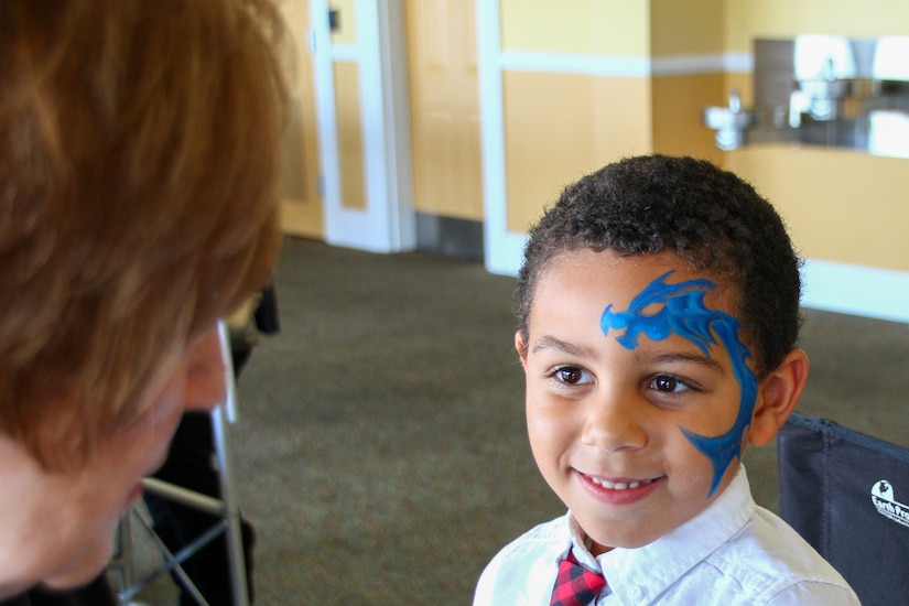 Darrin Kristopher Payne, the nephew of fallen Soldier Sgt. Darrin K. Potter of the 223rd Military Police Company, gets his face painted at the Survivor Outreach Services Day at the Races at Churchill Downs in Louisville, Ky. Nov. 7, 2021. Survivors Outreach Services Day at the Races is an annual event held to honor the lives of fallen services members. (U.S. Army National Guard photo by Sgt. Matt Damon)