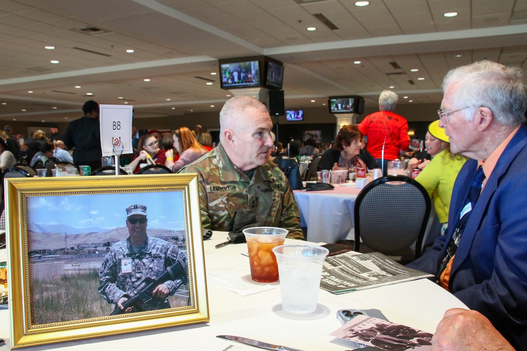 Maj. Gen. Hal B. Lamberton, the Adjutant General of Kentucky, discusses the life of fallen soldier Capt. Scott McLean (in the photograph) with Paul McLean, Capt. McLean’s father, at the Survivor Outreach Services Day at the Races at Churchill Downs in Louisville, Ky. Nov. 7, 2021. Survivor Outreach Services Day at the Races is an annual event held to honor the lives of fallen services members. (U.S. Army National Guard photo by Sgt. Matt Damon)