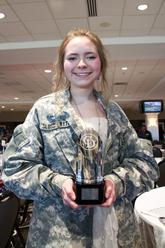 Hannah Sluss-Tiller, the daughter of fallen soldier Sgt. 1st Class Matthew Sluss-Tiller of the 96th Civil Affairs Battalion, poses with the trophy from the dedicated race at the Survivor Outreach Services Day at the Races at Churchill Downs in Louisville, Ky. Nov. 7, 2021. This is the first time that the trophy has been given to the Gold Star Family member. (U.S. Army National Guard photo by Sgt. Matt Damon)
