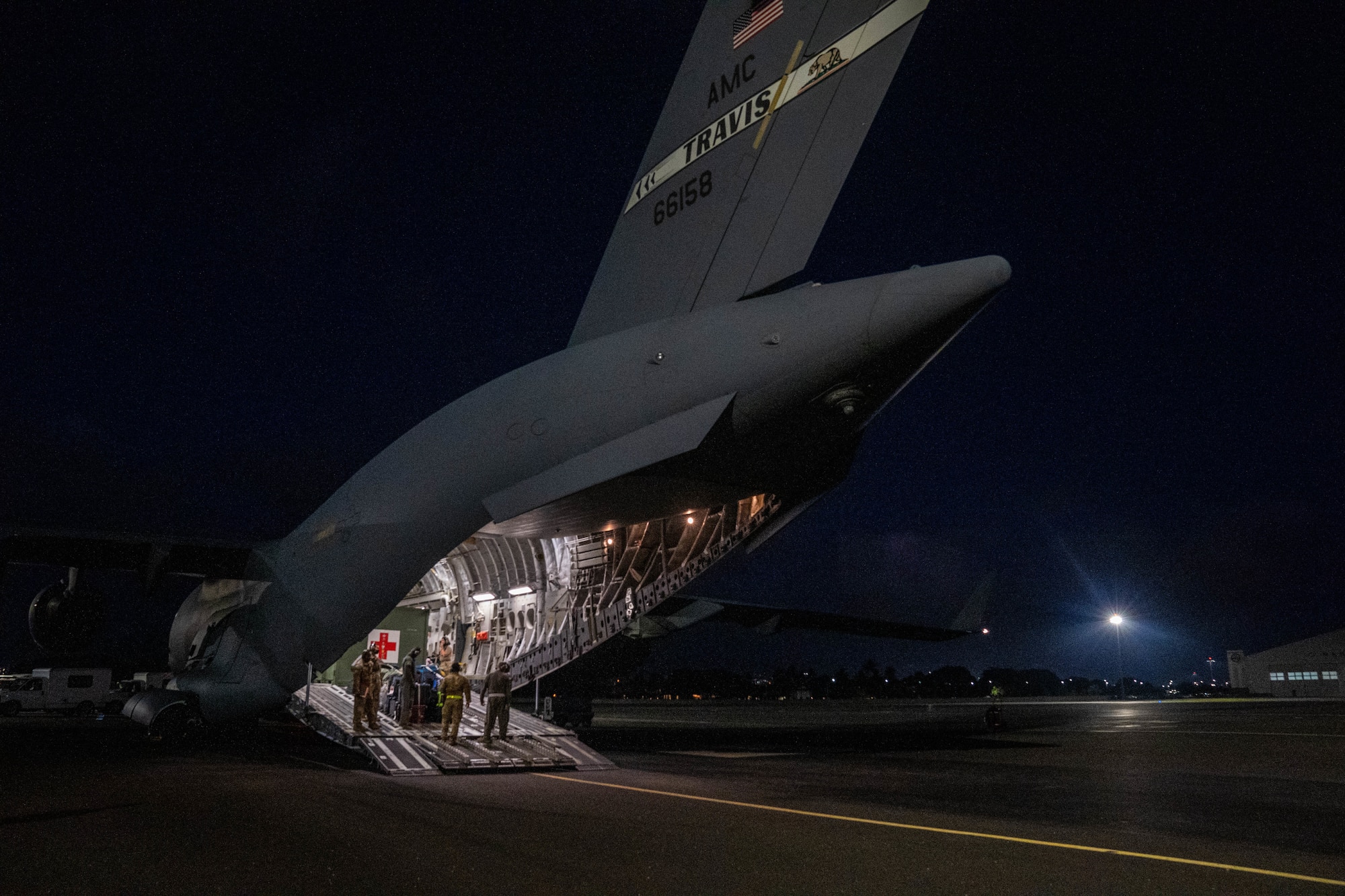 Airmen assigned to Travis Air Force Base, California, work together with Airmen from several units at Joint Base Pearl Harbor-Hickam, Hawaii, to care for and transport patients to medical facilities during an aeromedical evacuation mission at JBPHH, Hawaii, Nov. 4, 2021. Aeromedical evacuation crews execute patient care and patient movement on a U.S. Air Force aircraft and can operate in austere locations.(U.S. Air Force photo by Airman 1st Class Makensie Cooper)