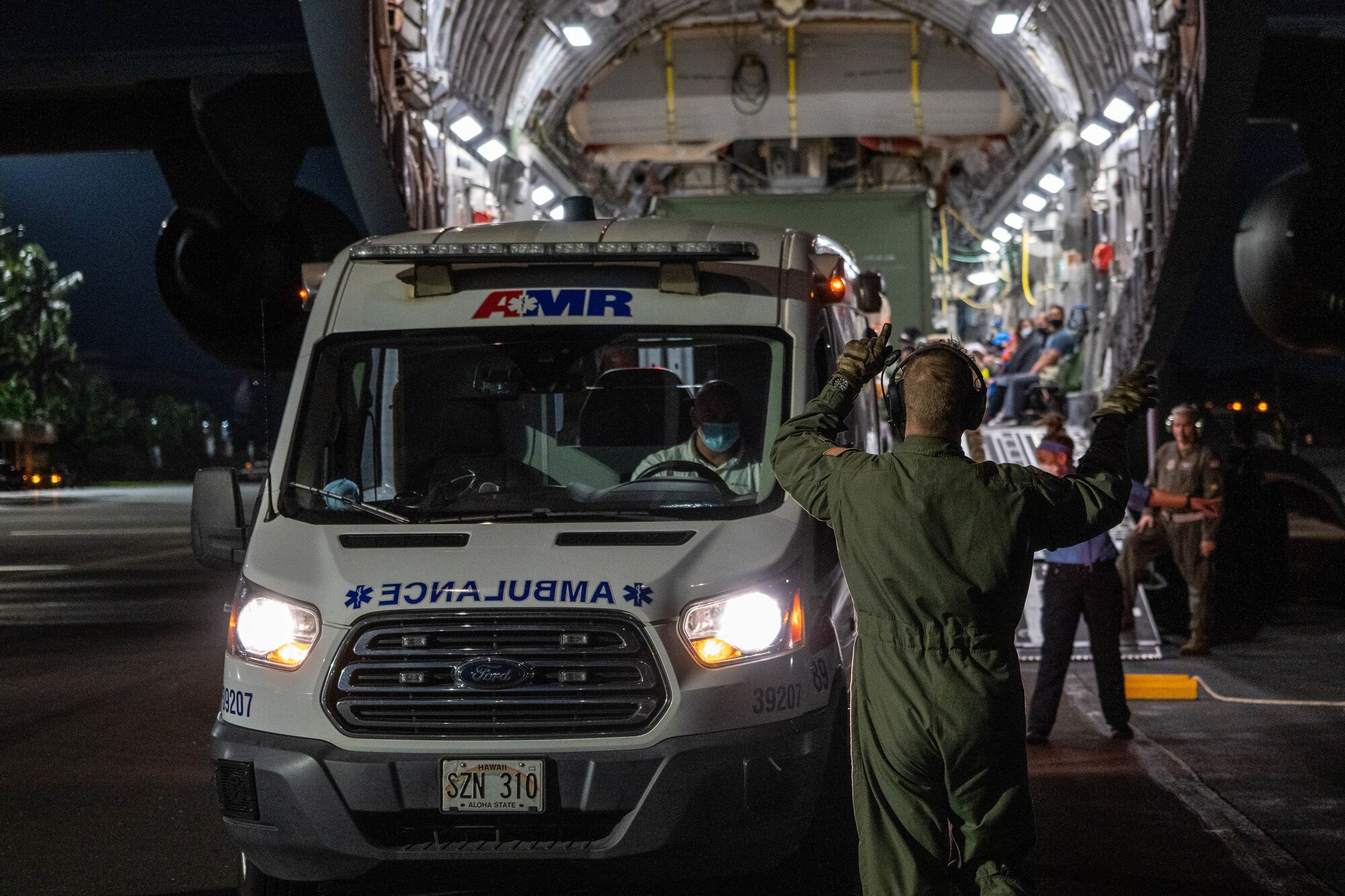 Airmen assigned to the 60th Operations Group direct an ambulance to help aid and care for patients during an aeromedical evacuation mission at Joint Base Pearl Harbor-Hickam, Hawaii, Nov. 4, 2021. Airmen from Travis Air Force Base, California, and JBPHH worked together to ensure the safety of patients on the ground after landing. (U.S. Air Force photo by Airman 1st Class Makensie Cooper)