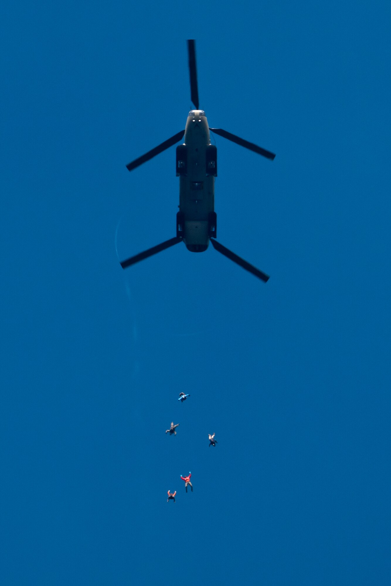 U.S. Air Force pararescuemen assigned to the 212th Rescue Squadron, Alaska Air National Guard, leap from a CH-47F Chinook operated by Detachment 1, Bravo Company, 2-211th General Service Aviation Battalion, during a training event at Joint Base Elmendorf-Richardson, Alaska.