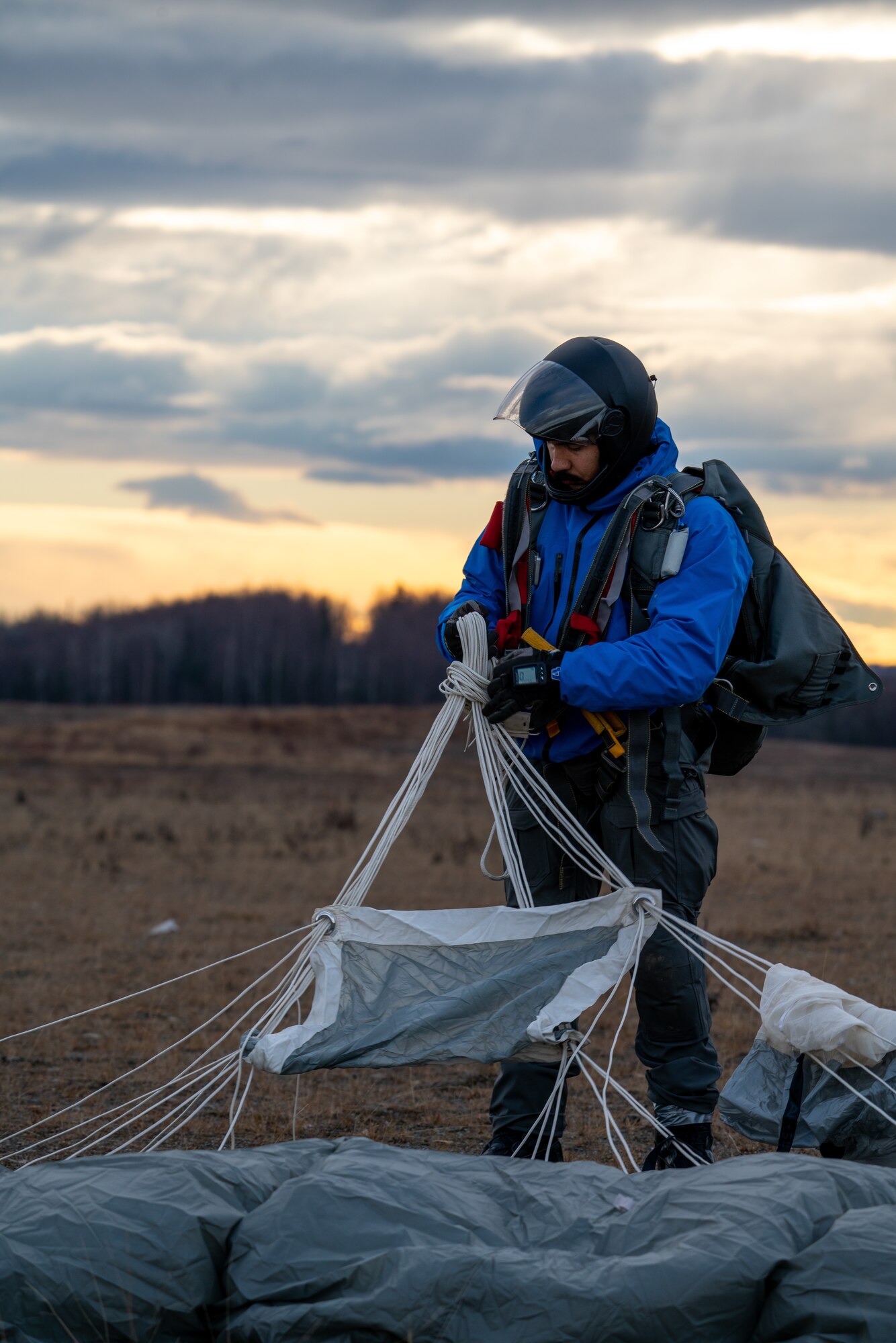 U.S. Air Force Staff Sgt. Thomas Aycart-Meija, a pararescueman assigned to the 212th Rescue Squadron, Alaska Air National Guard, recovers his parachute after a successful jump at a Joint Base Elmendorf-Richardson.