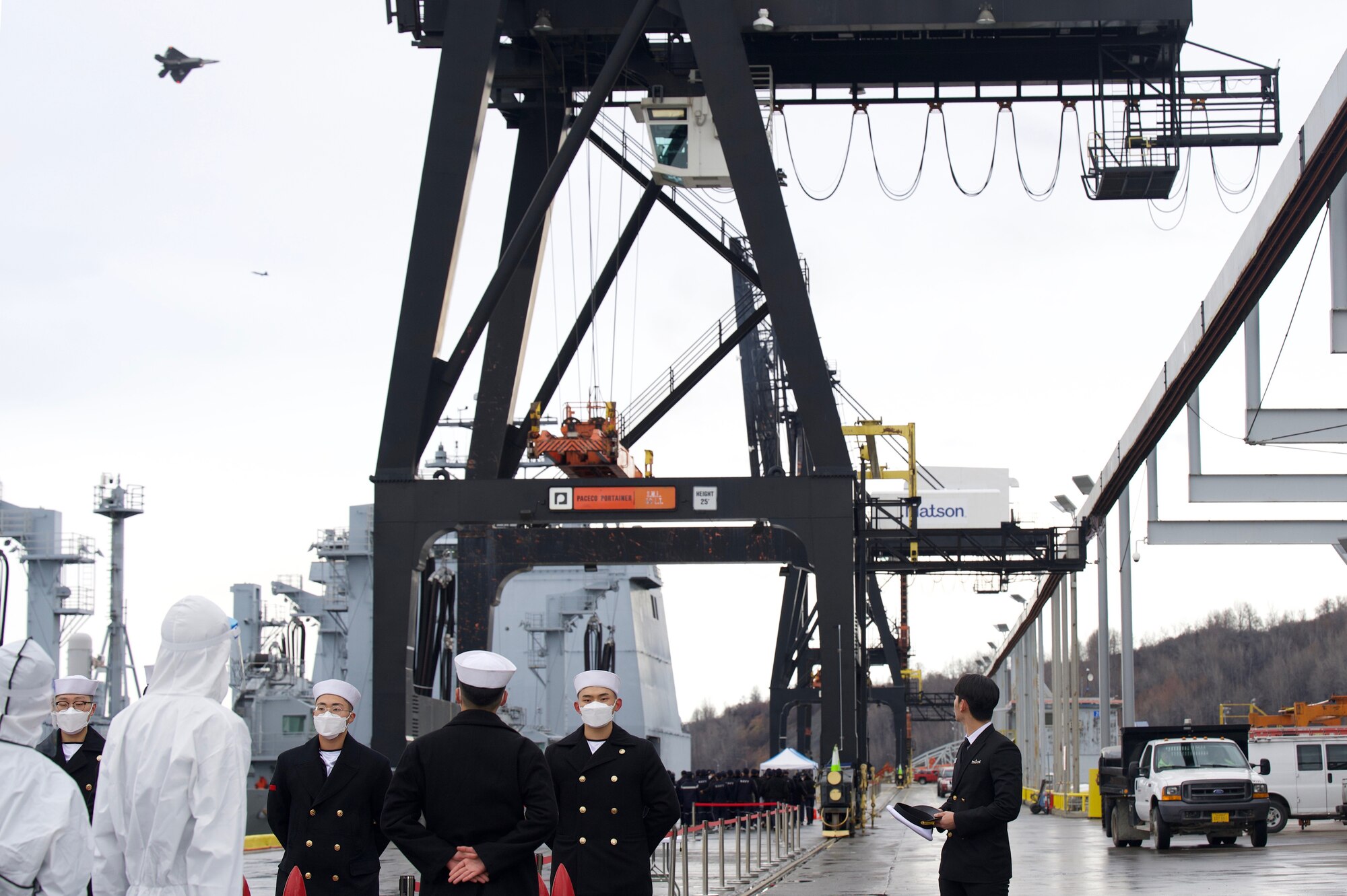 Midshipmen from the Republic of Korea Navy (ROKN) Cruise Training Task Group’s two vessels, a Republic of Korea Ship (ROKS) Wang Geon (DDH-978) Chungmugyon Yi Sun-sin-sin-class destroyer and ROKS So Yan (AOE-51), a combat support ship, watch as an F-22 Raptors passes by at the Port of Alaska, Anchorage, Nov. 4, 2021. The ROKN Cruise Training Task Group visited Alaska during a 67-day voyage, which marked the first ever trip for ROKN vessels to the state.(U.S. Air Force photo by Sheila deVera)