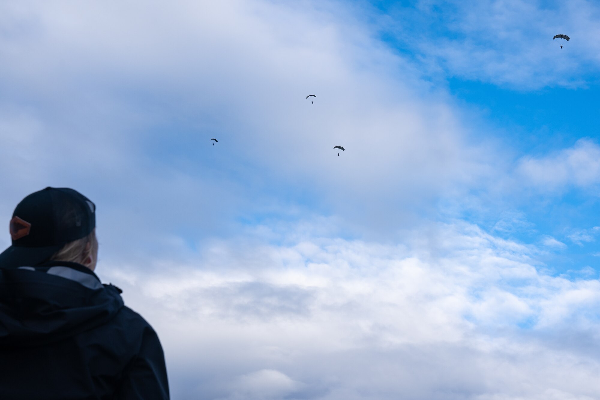 U.S. Air force Master Sgt. Sara Jones, an aircrew flight equipment technician assigned to the 212th Rescue Squadron, Alaska Air National Guard, looks on as 212th Rescue Squadron pararescuemen descend upon Malemute Drop Zone during a training event at Joint Base Elmendorf-Richardson.